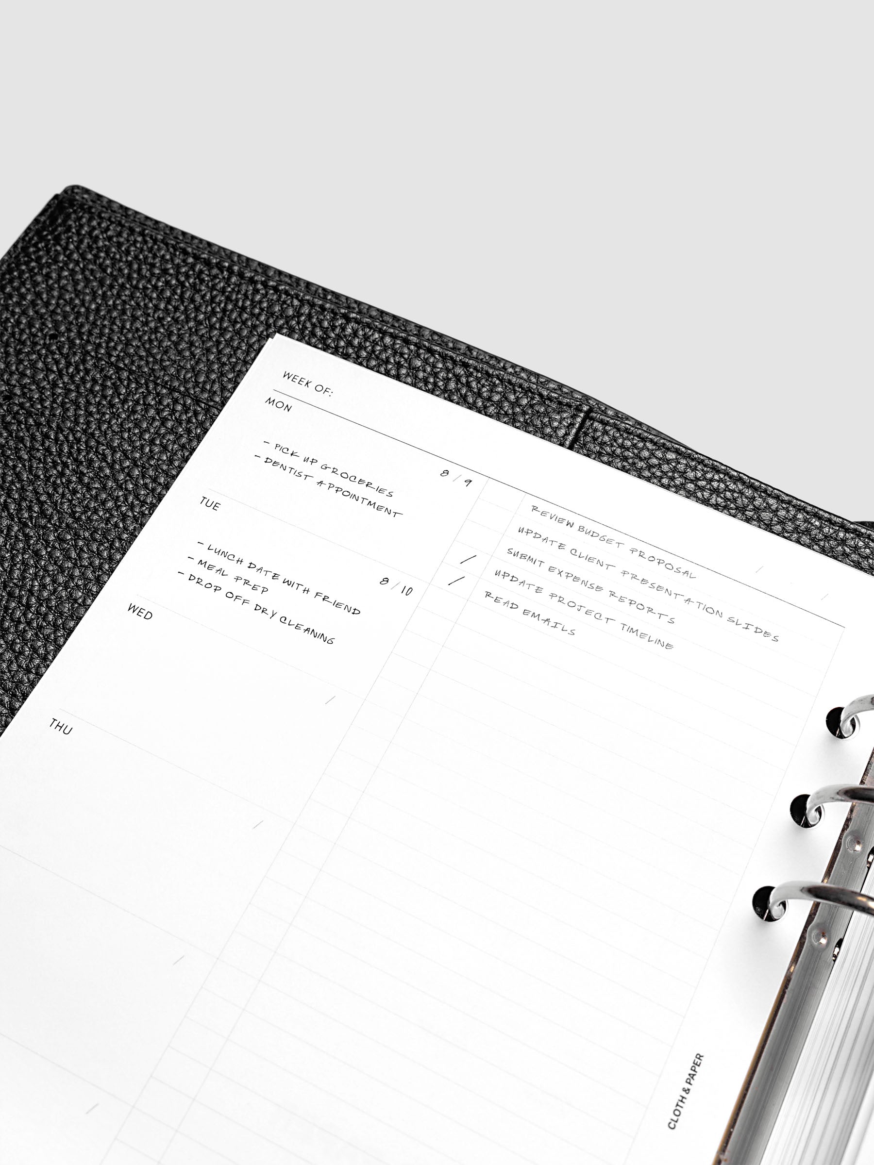 Close up view of the planner inserts demo pages in a black leather agenda.