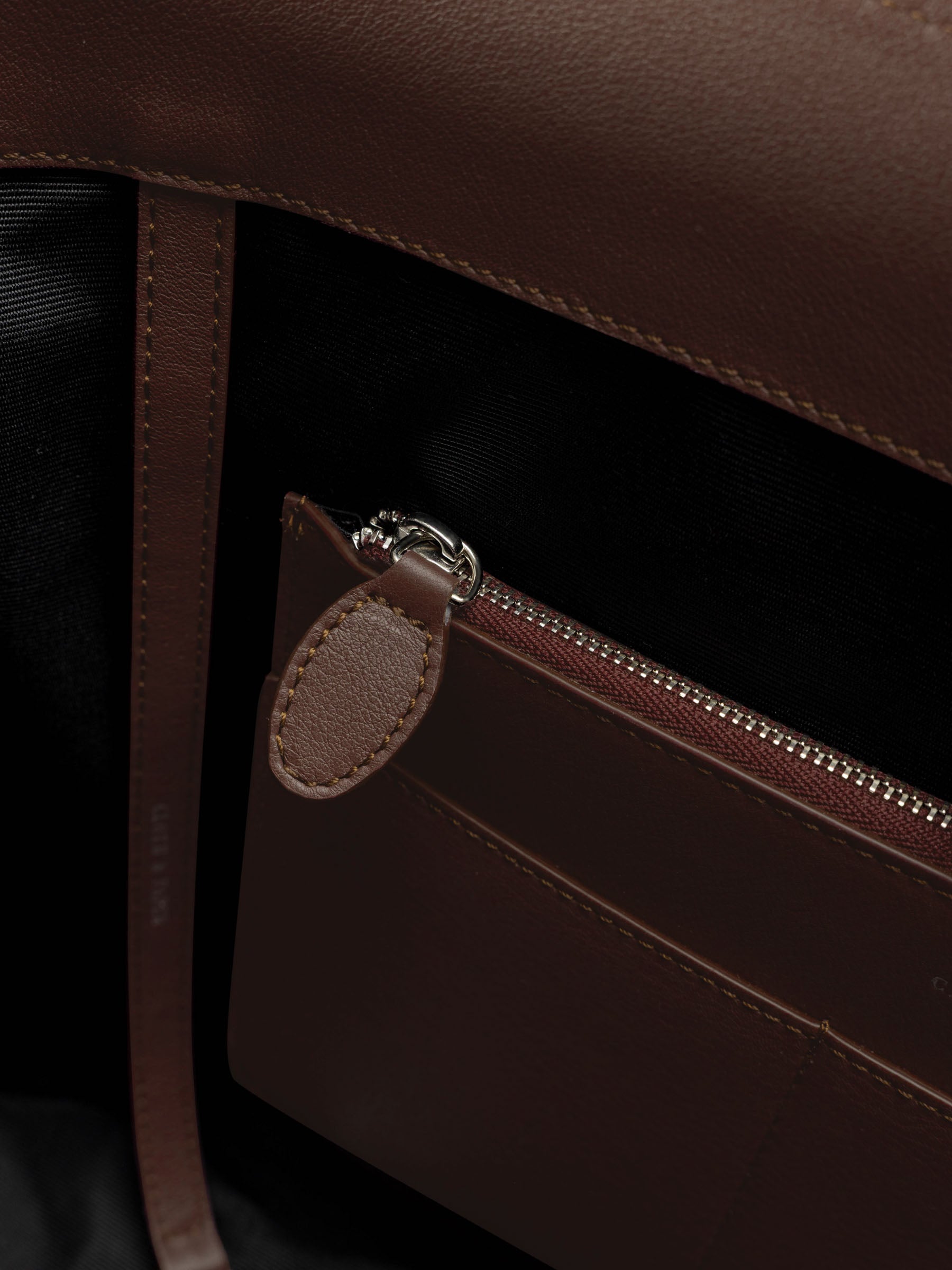 Detail view of the zip closure inner pocket on The Metro Tote in the color Cordoba.