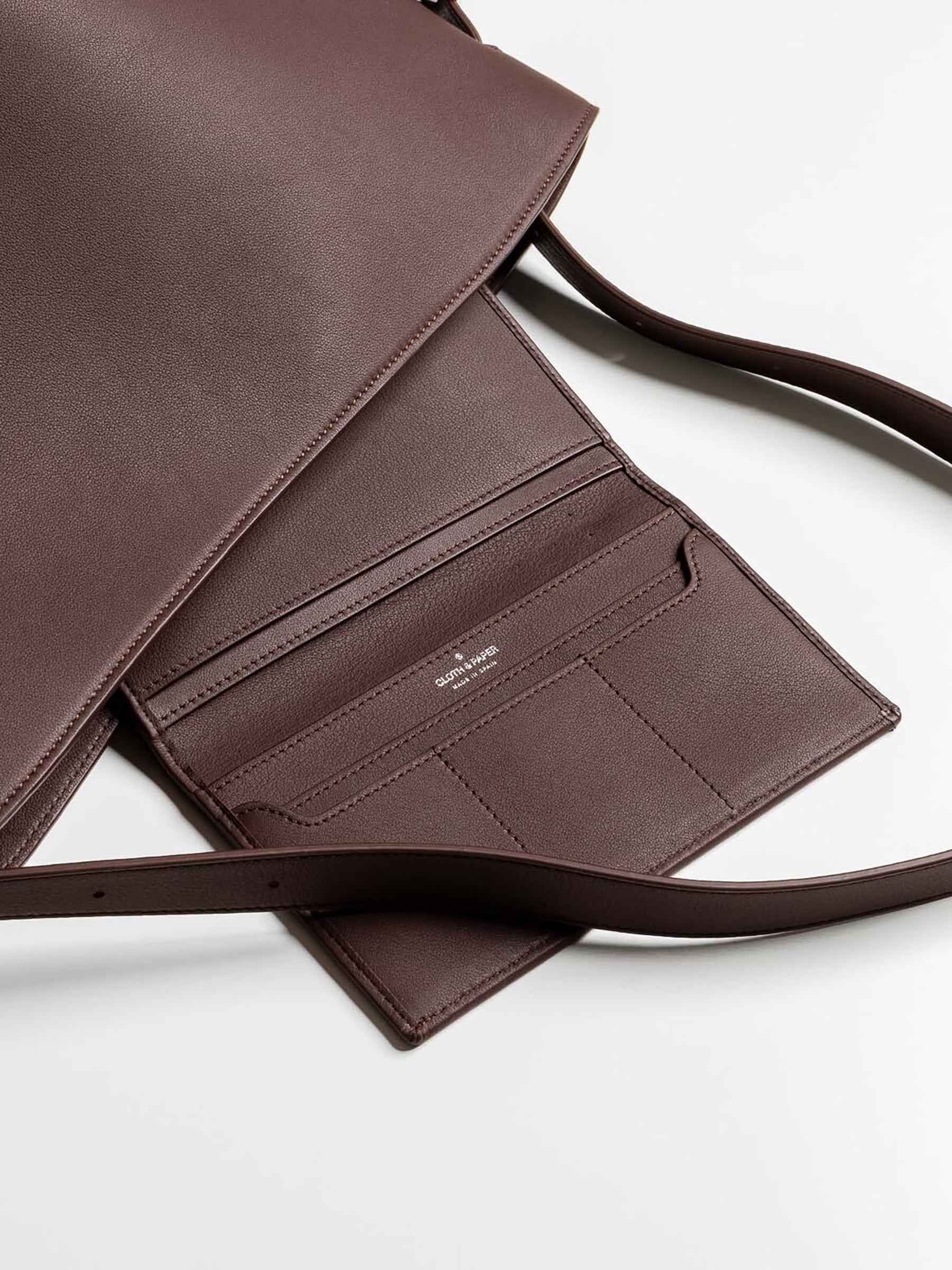 Brown leather wallet nested in a brown leather tote bag.