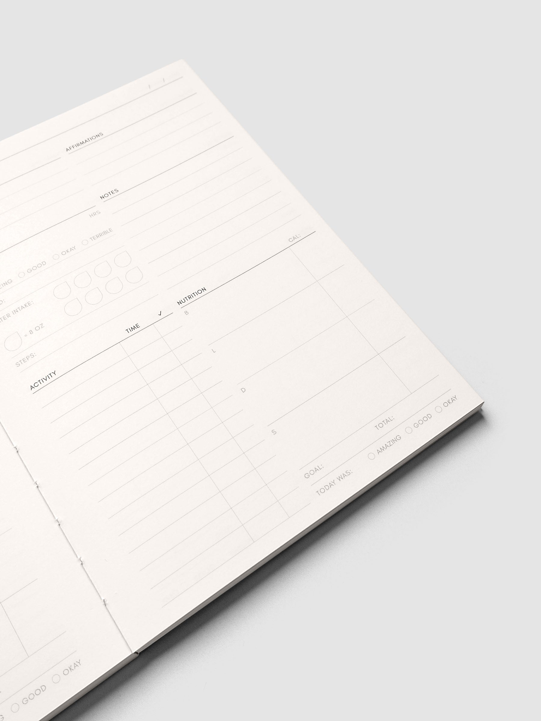 Close up of the Perfect Bound Notebook | A5 | Daily Wellness pages at an angle, showing the column structure across the spread