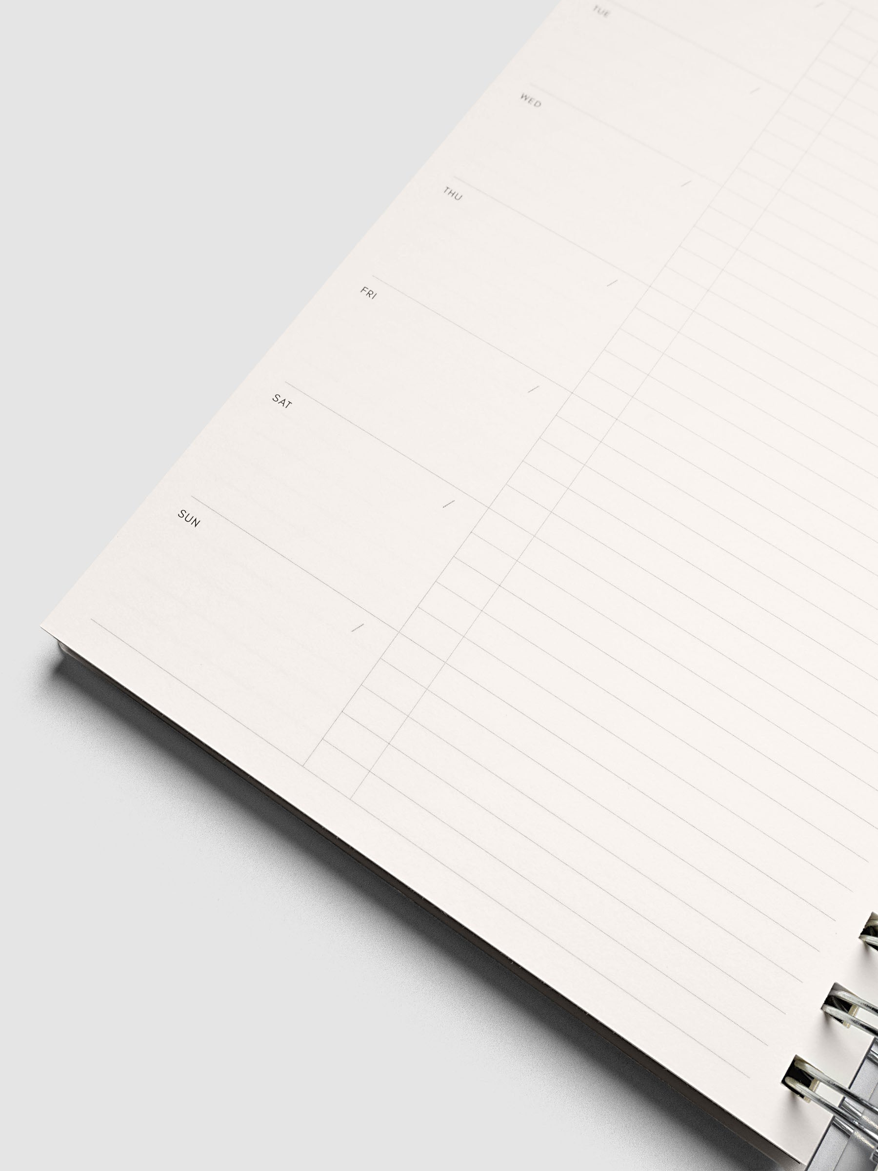 Close up of the Spiral Notebook | A5 | Weekly Checklist with a page lifting at an angle, showing ruled lines and silver spiral binding