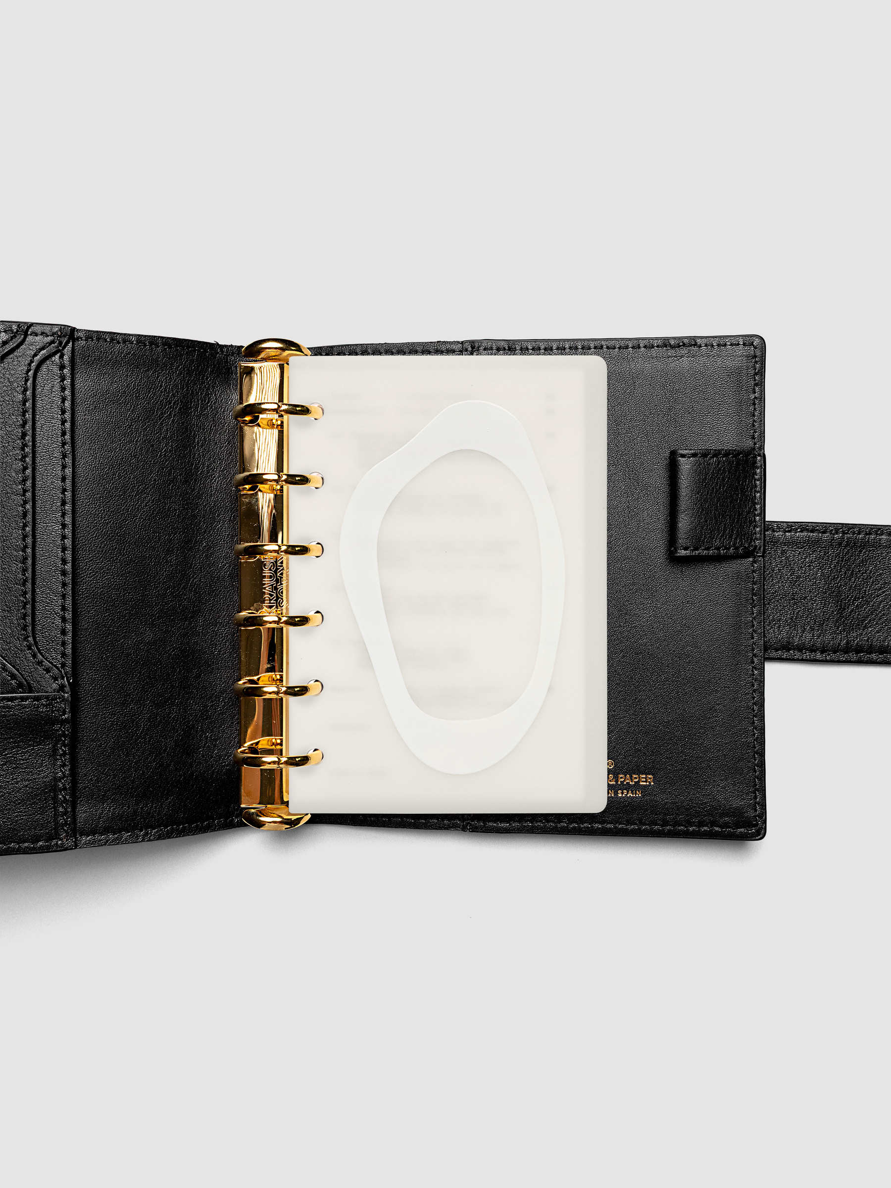 Continuation Planner Cover + Dashboard Set in Pocket. Milky white frosted plastic cover with a spot gloss organic shape over a black-printed paper dashboard. Image 3 of 3.