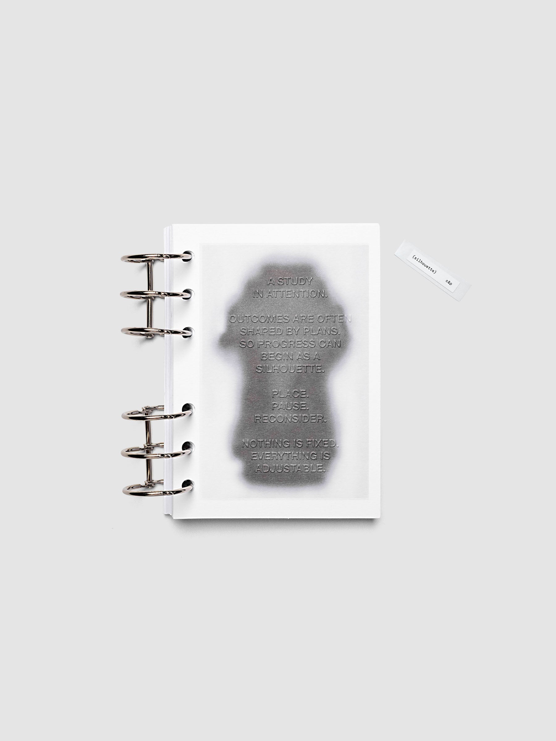 Silhouette Planner Dashboard in A6. Greyscale silhouette print with embossed text on paper. Image 2 of 2.