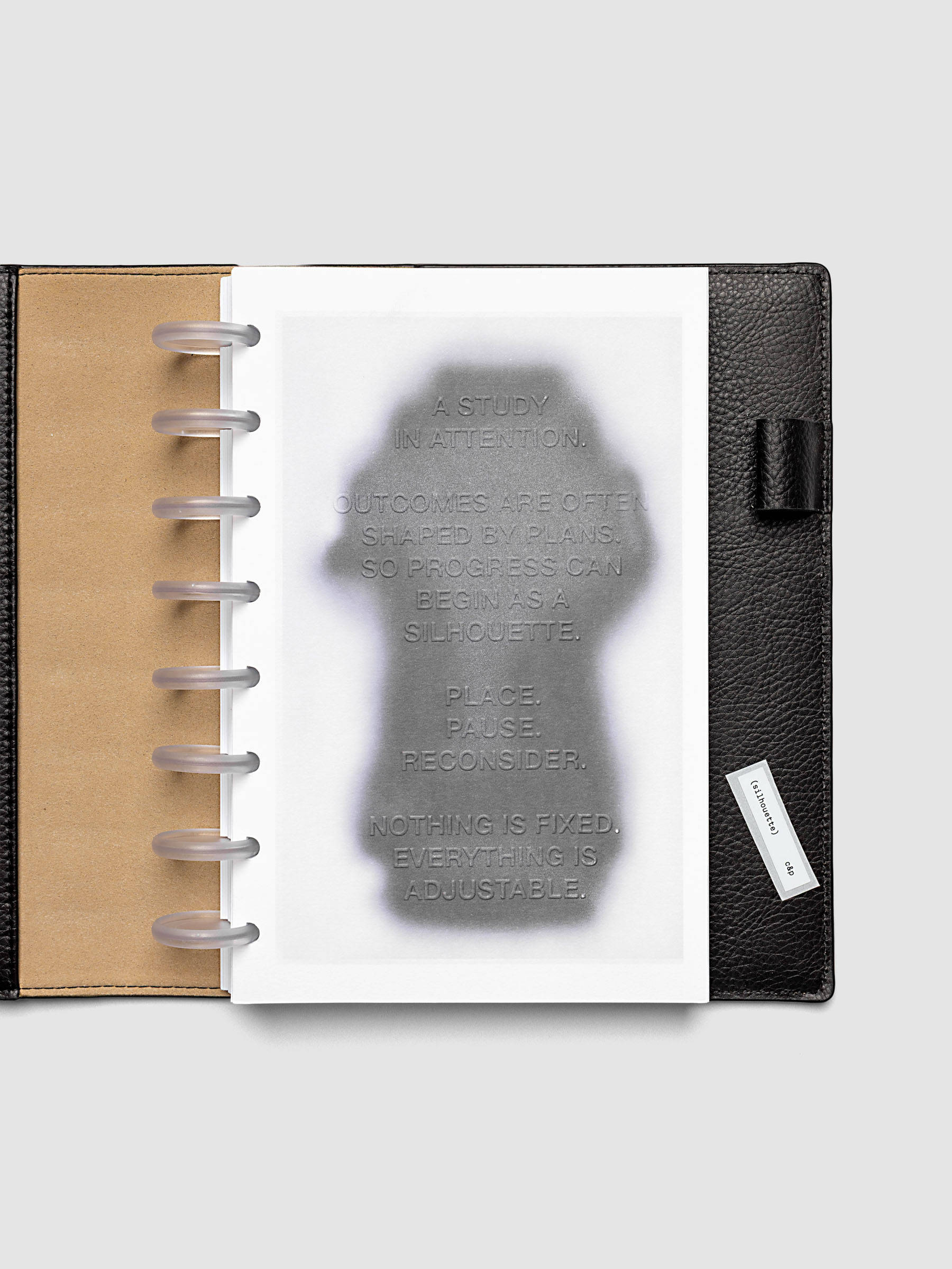 Silhouette Planner Dashboard in Half Letter 8-Disc Punch. Greyscale silhouette print with embossed text on paper. Image 2 of 2.