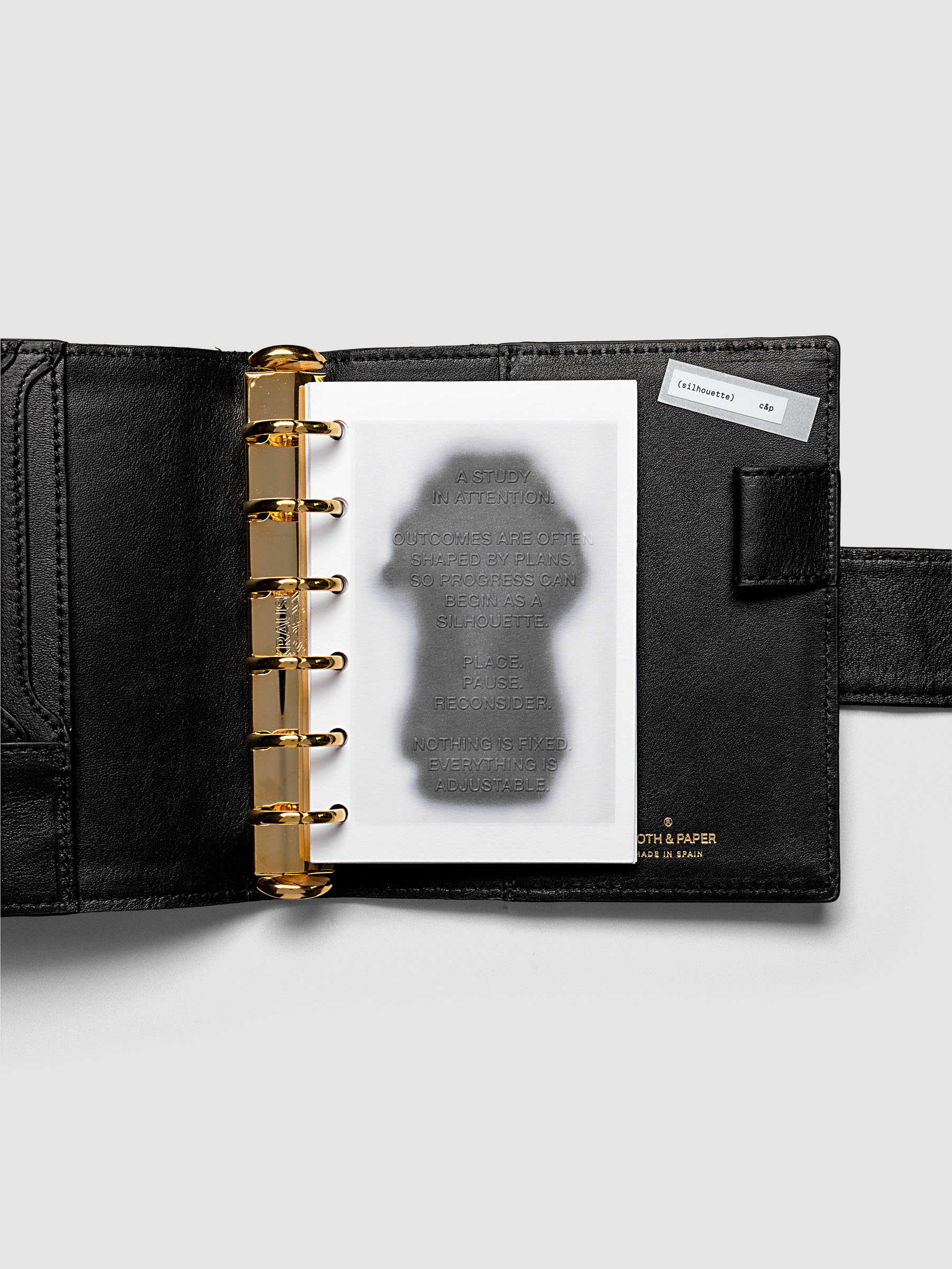 Silhouette Planner Dashboard in Pocket. Greyscale silhouette print with embossed text on paper. Image 2 of 2.