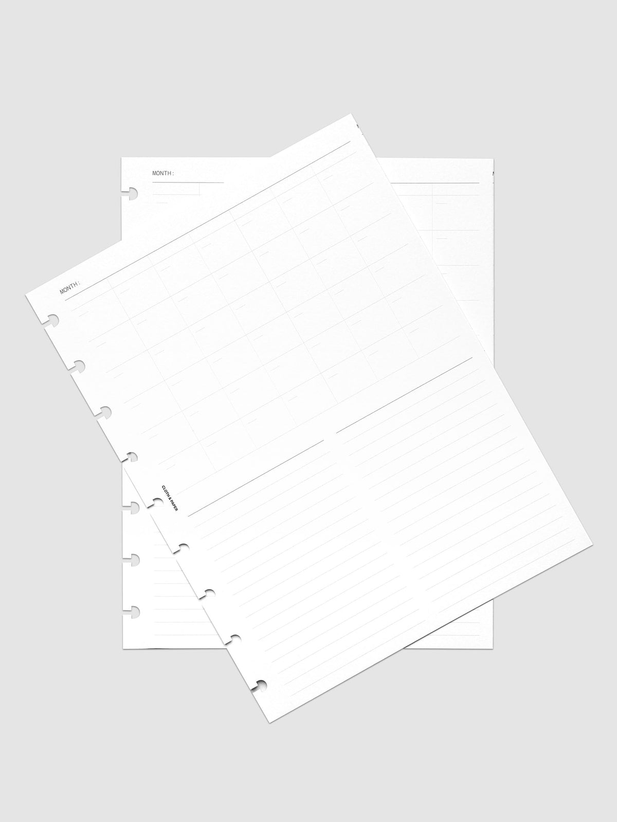 Monthly Fold Out Planner Insert Set of 2, HP Classic 9-Disc Punch, both inserts of the set layered at an angle on a pale gray surface, nine disc notches along the left edges