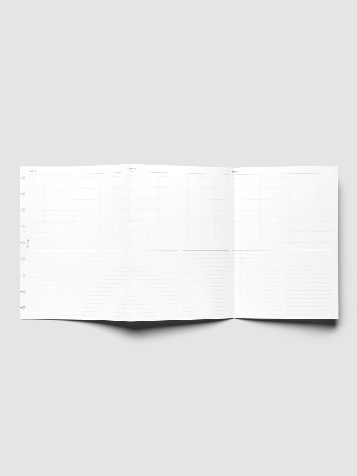 Monthly Fold Out Planner Insert Set of 2, HP Classic 9-Disc Punch, the insert unfolded and standing open, showing three monthly grid panels side by side