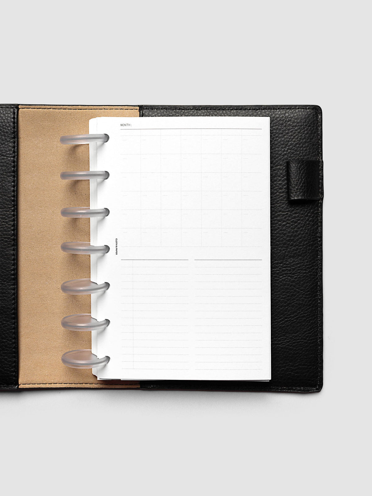Monthly Fold Out Planner Insert Set of 2, HP Mini 7-Disc Punch, the insert folded closed in a black pebbled leather discbound planner with frosted clear discs and a kraft brown interior panel