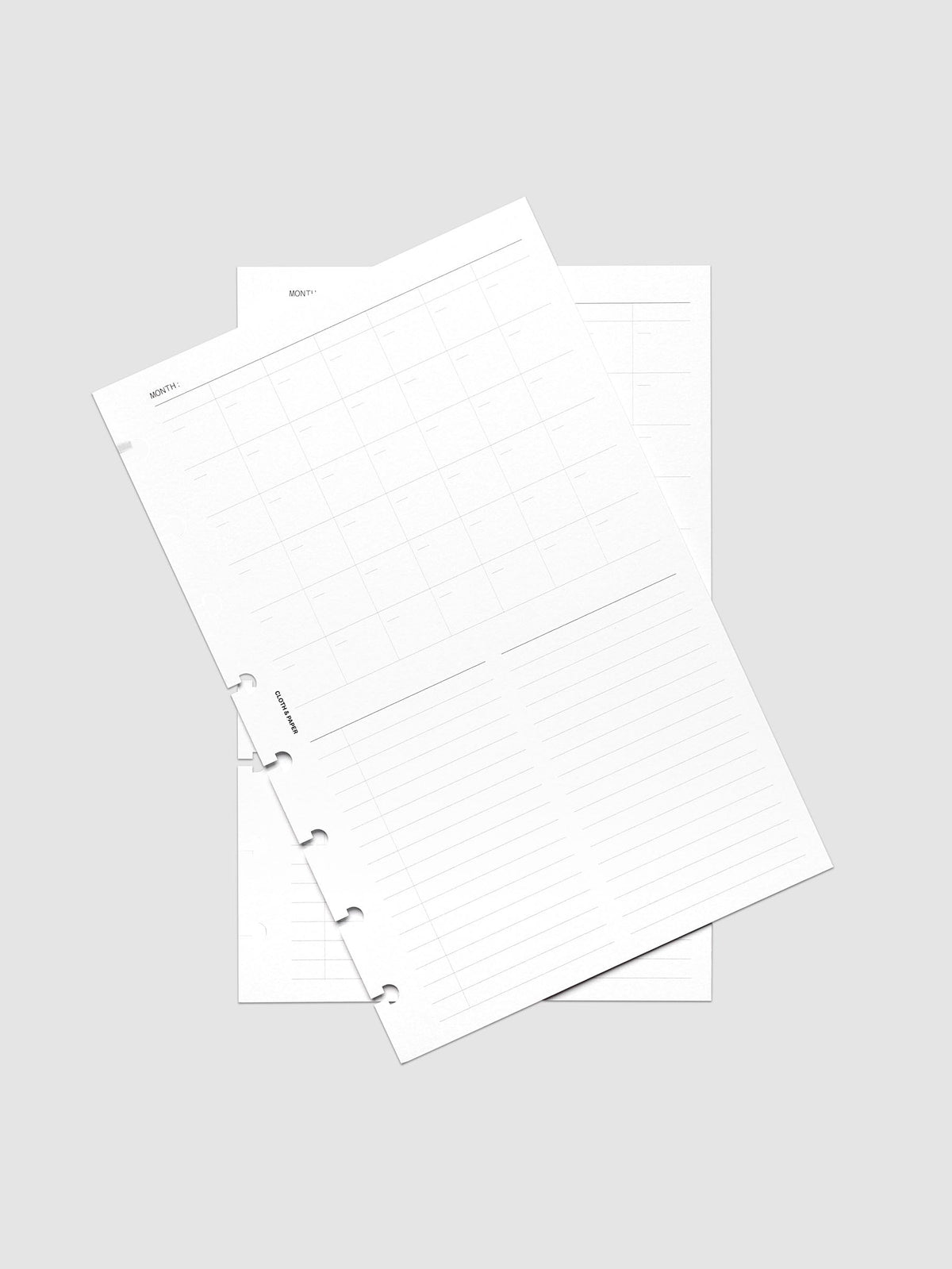 Monthly Fold Out Planner Insert Set of 2, Half Letter 8-Disc Punch, both inserts of the set overlapping at an angle, the top sheet showing the gray monthly grid and lined note columns