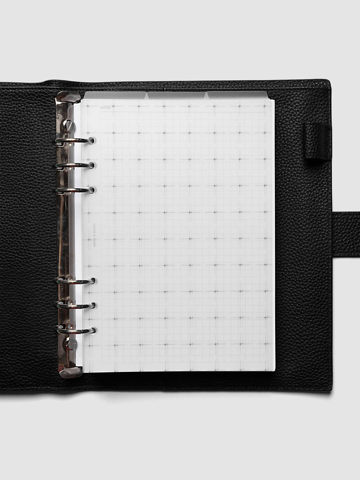 Grid Top Tab Dividers | Ultra-Thin, A5 6-Ring Punch, dividers loaded in a black pebbled leather ring bound planner with silver rings, three staggered tabs across the top and a white grid notes insert underneath