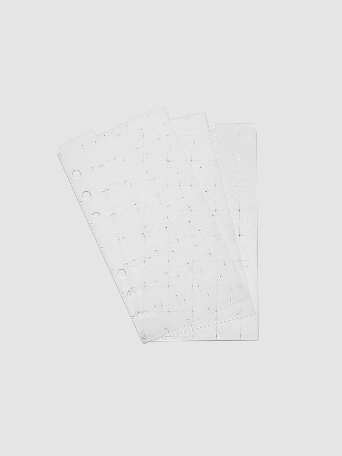 Grid Top Tab Dividers | Ultra-Thin, Personal 6-Ring Punch, the three dividers fanned at an angle, ring holes and black grid print showing through the translucent plastic