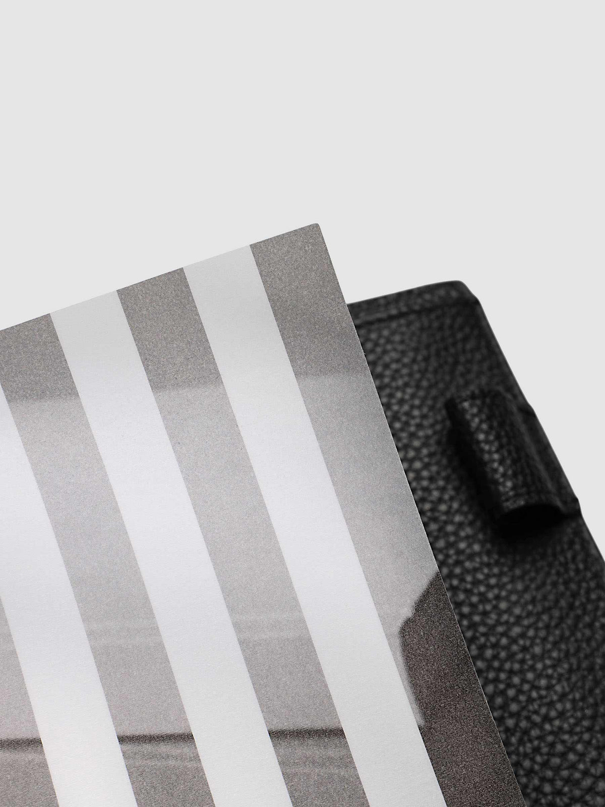 Close-up of the top corner of the vellum base layer of the A5 6-Ring Punch Strips Planner Dashboard Duo, showing the matte printed strips against a black pebbled leather cover