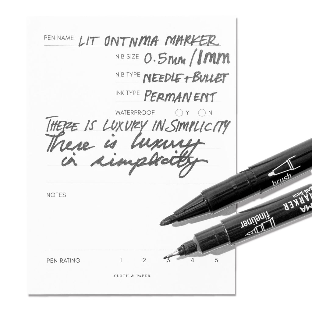 Two Lit Ontnma markers, one with its bullet nib displayed and one with its fineliner tip displayed, shown on an in use pen testing sheet.