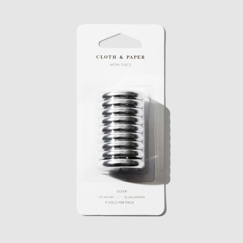 Silver discs displayed in their packaging on a gray background. 
