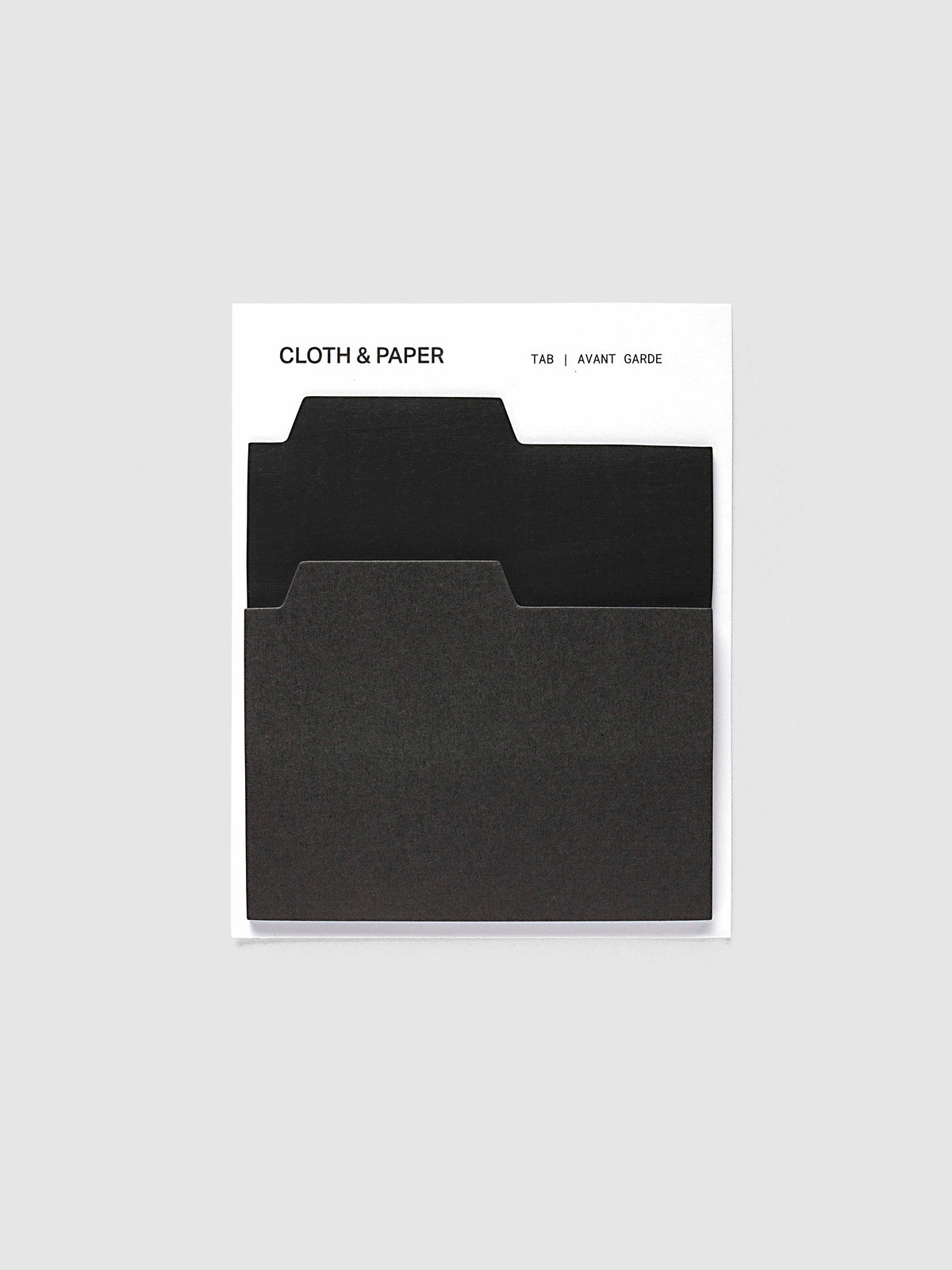 Blank Tab Sticky Note Set, Avant Garde, Cloth and Paper. Set on its backing card, a transparent black pad behind a matte black pad with the tabs staggered.