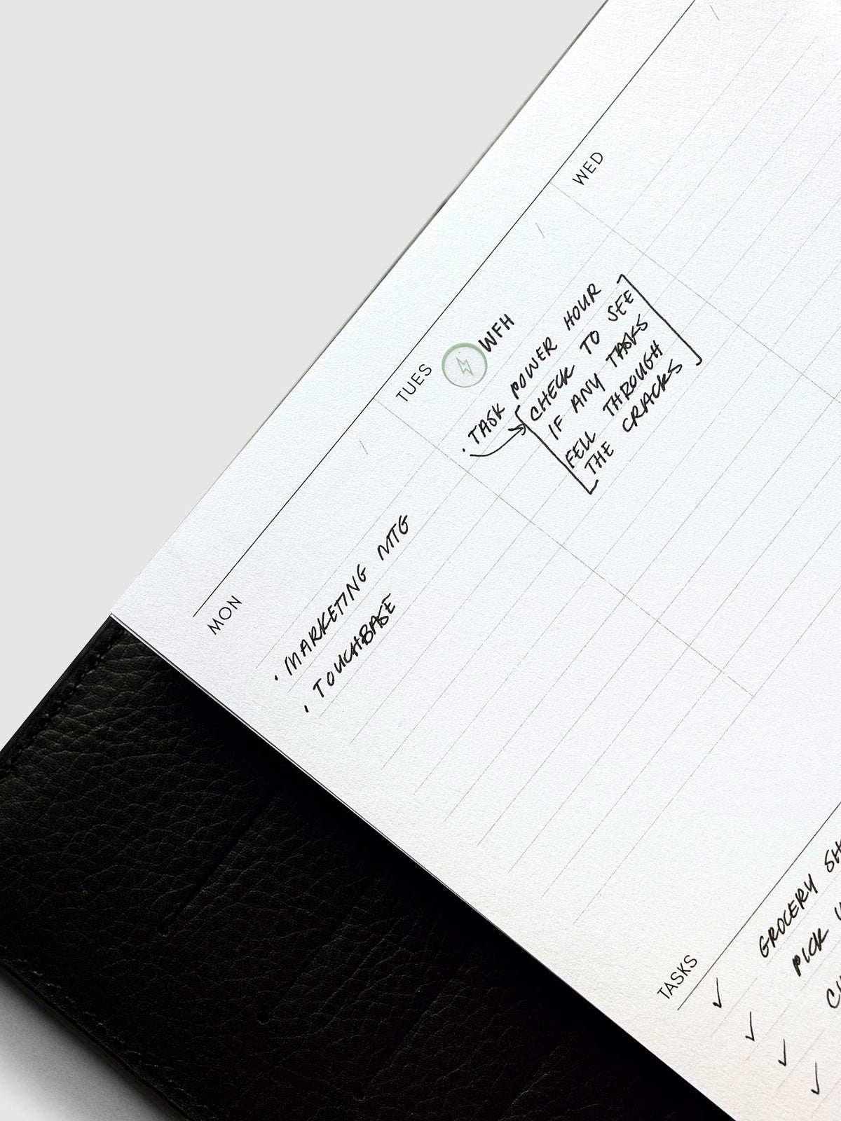 Weekly Essentials Planner Inserts, Half Letter 8-Disc Punch, angled close-up of the daily columns filled in by hand