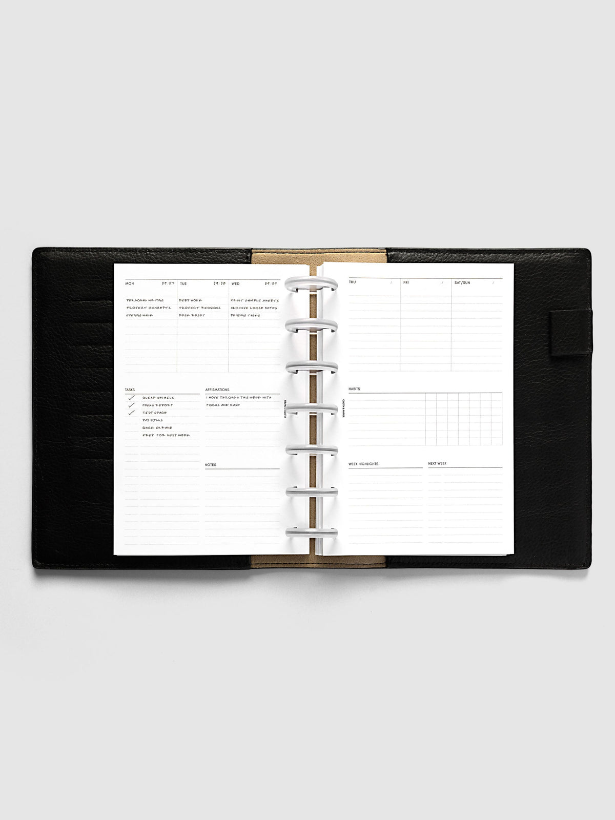 Weekly Essentials Planner Inserts, HP Mini 7-Disc Punch, weekly spread open on frosted discs in a black leather planner