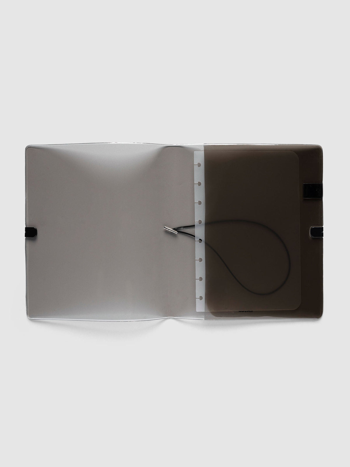 Folio Cover in black tinted vinyl, Large (Half Letter 8-Disc Punch), open flat showing the punched disc strip and the black bungee cord inside