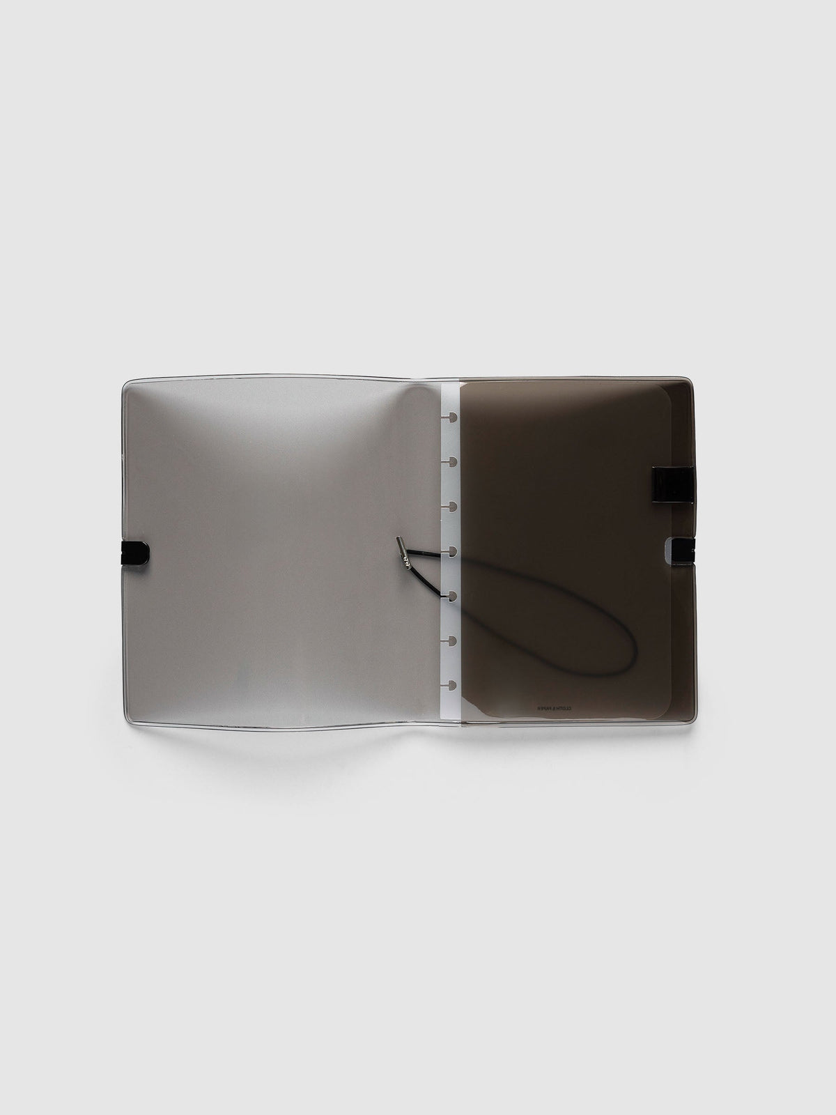 Folio Cover in black tinted vinyl, Small (HP Mini 7-Disc Punch), open flat showing the punched disc strip and the black bungee cord inside