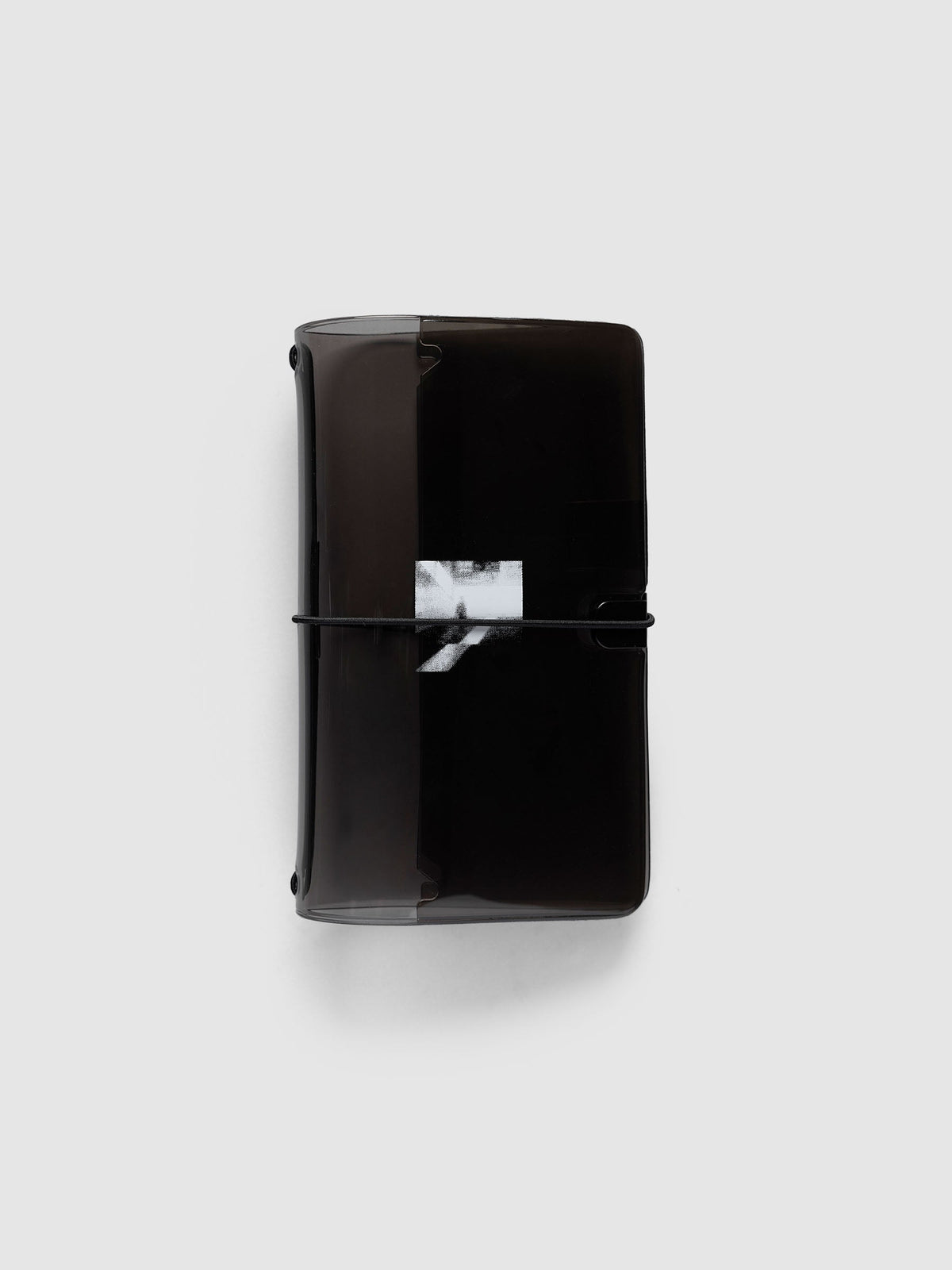 Image Duo Travel Cover, Pocket Plus, in tinted black vinyl, closed with a black elastic cord across the white halftone photo print