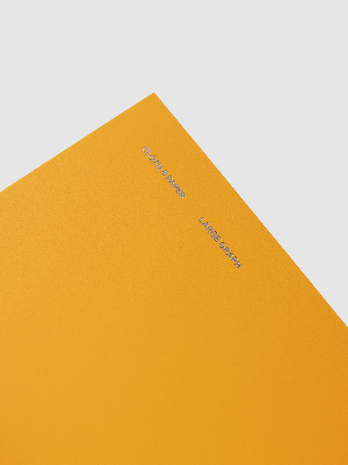 Close-up of the silver foil Cloth & Paper and Large Graph lettering on the orange Tangent cover