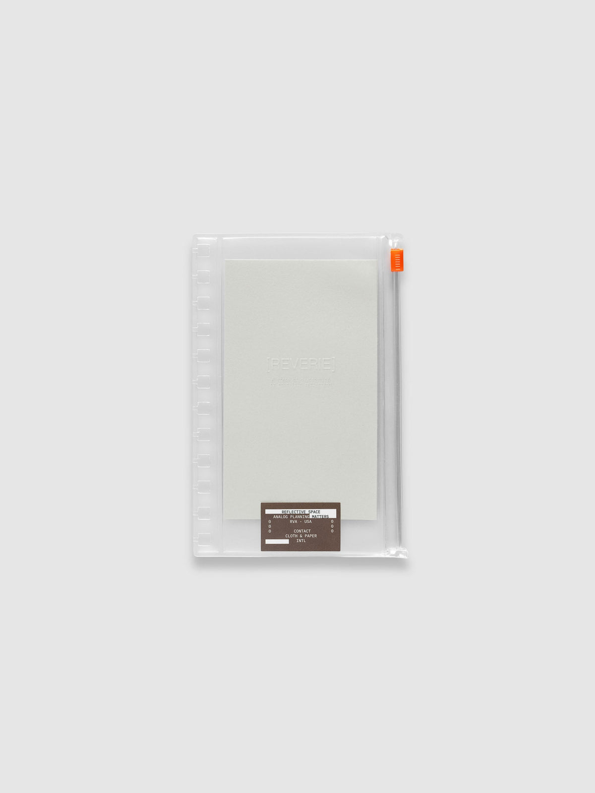 Clear zippered pouch with an orange zipper pull, pre-punched for CP Petite Spiral notebooks, holding a light grey embossed paper dashboard and a brown sticker. Shown in size CP Petite Spiral.