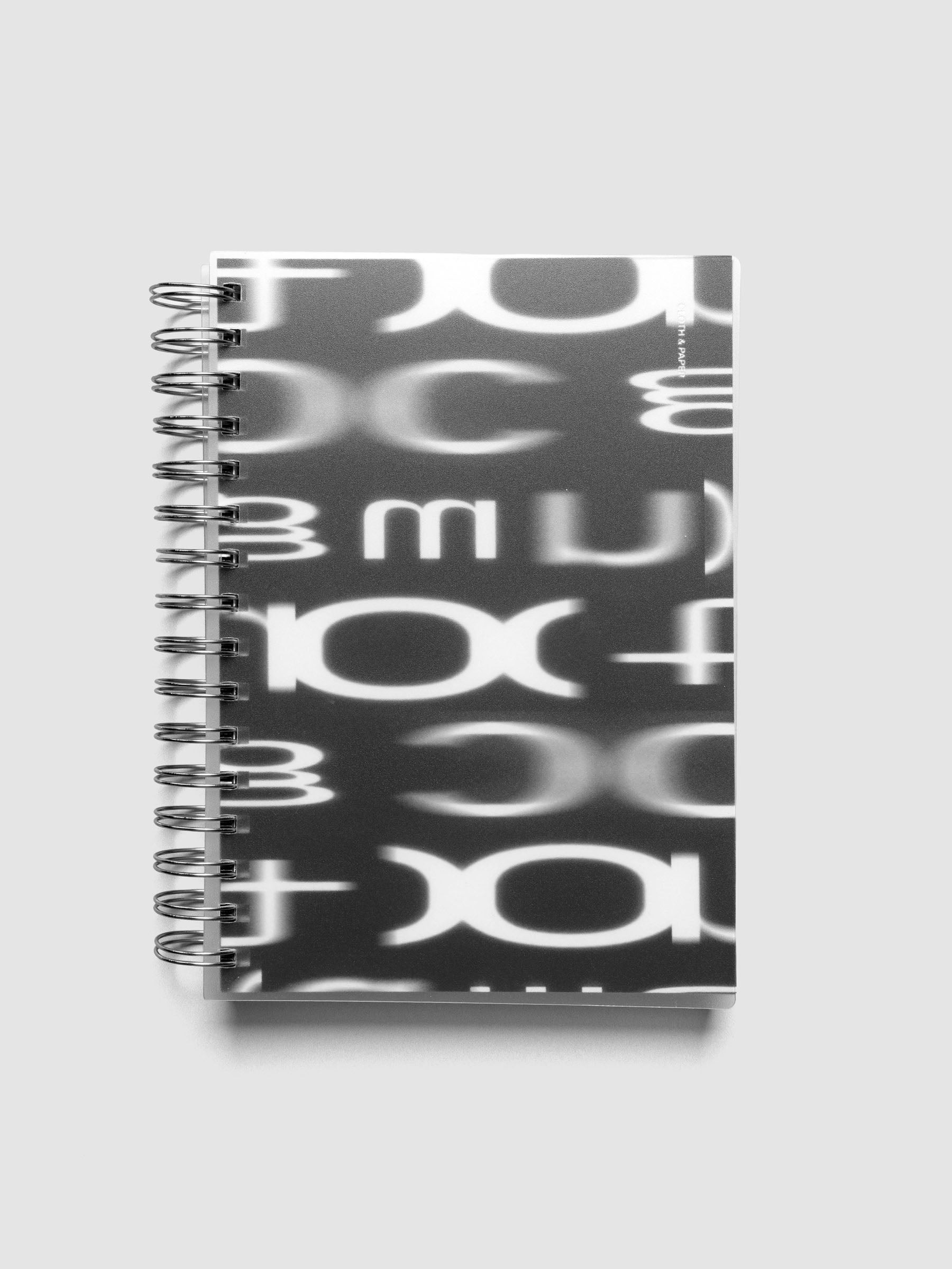 Spiral Notebook dashboard in the pattern Blurred Letters shown in size A5 inside a notebook with the frosted transparent cover overlayed.