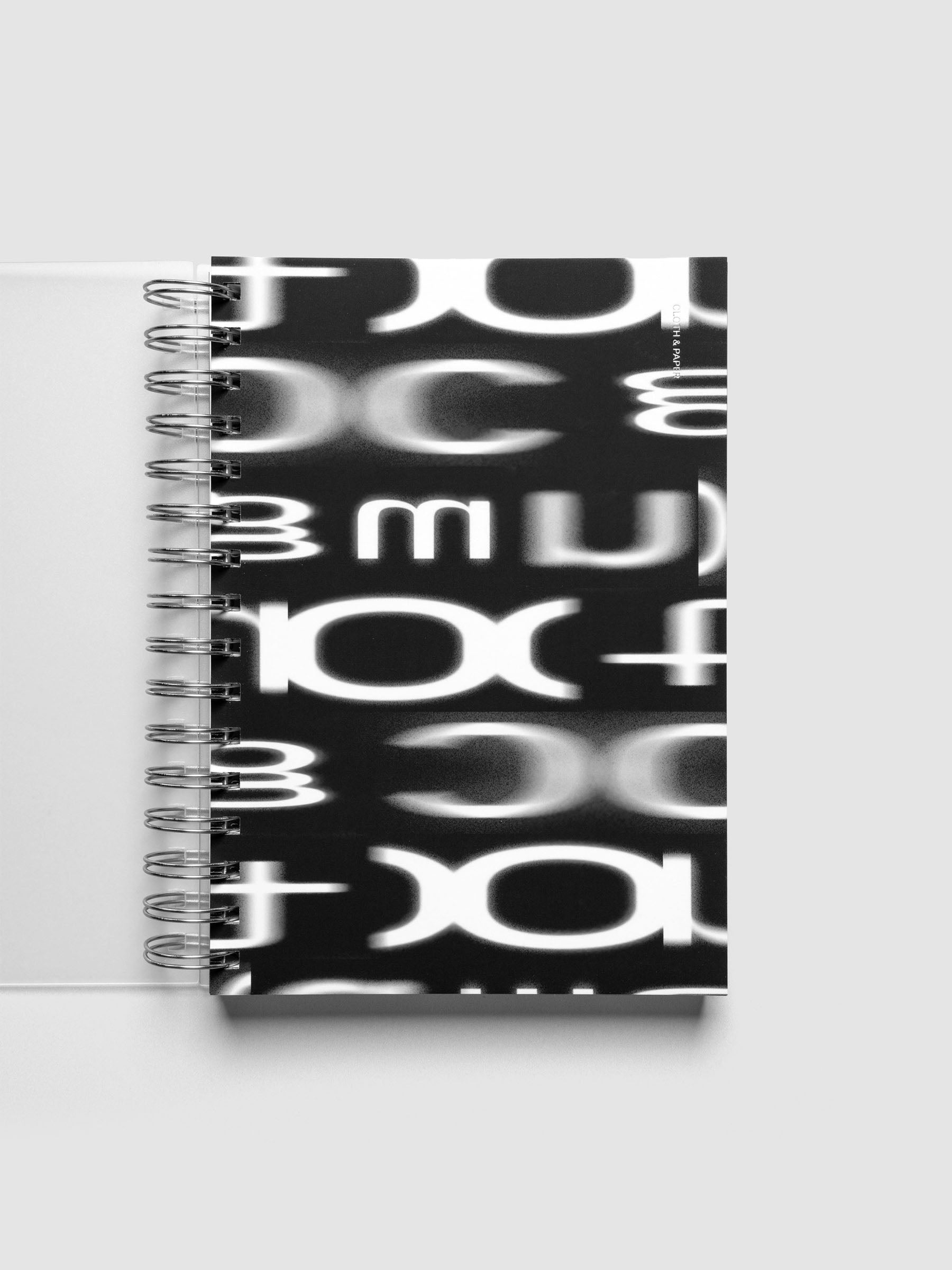 Spiral Notebook dashboard in the pattern Blurred Letters shown in size A5 inside a notebook.