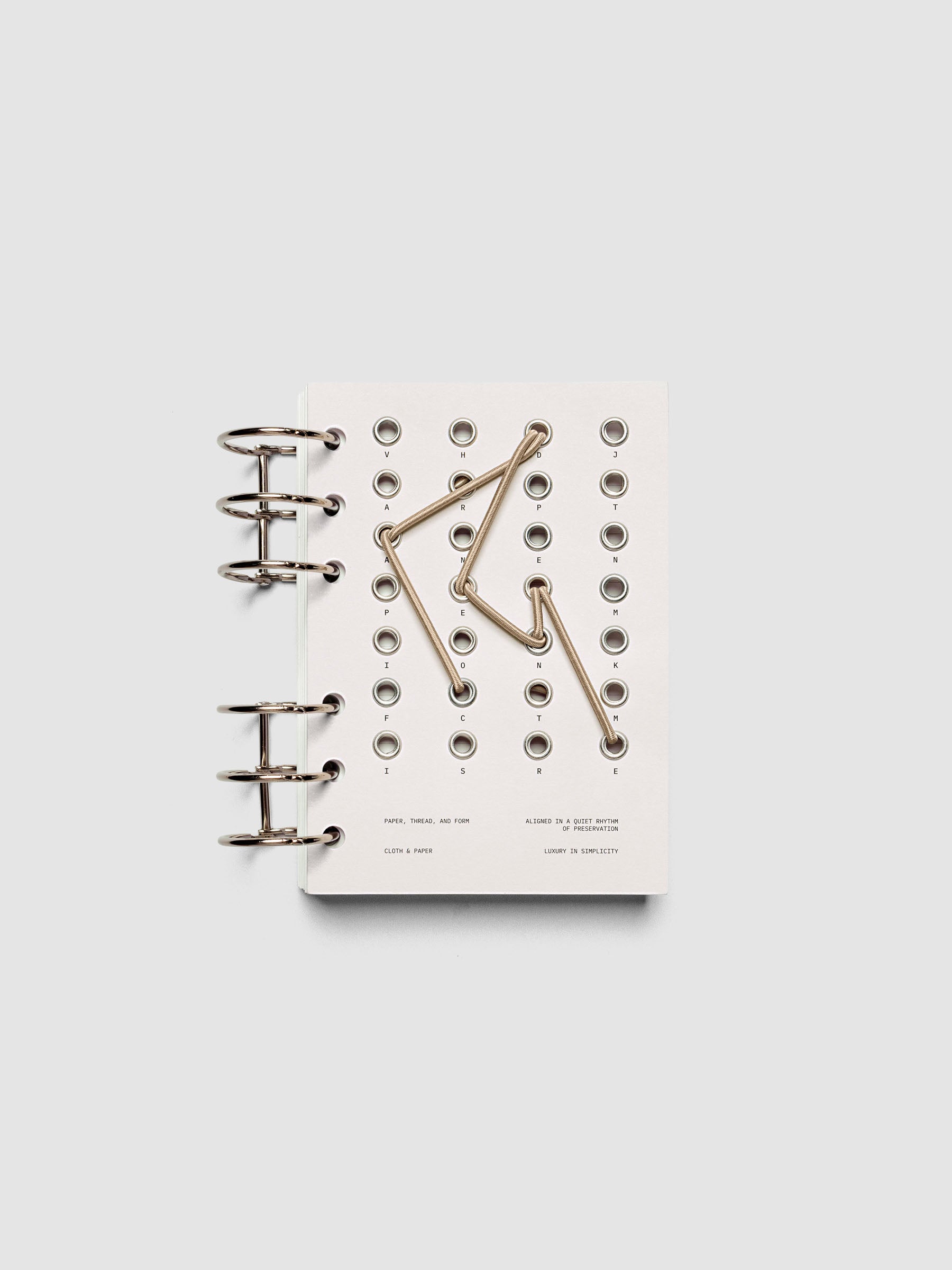 Cadence Dashboard with grommets and string on beige cardstock shown in size A6 for 6-ring planners and notebooks.