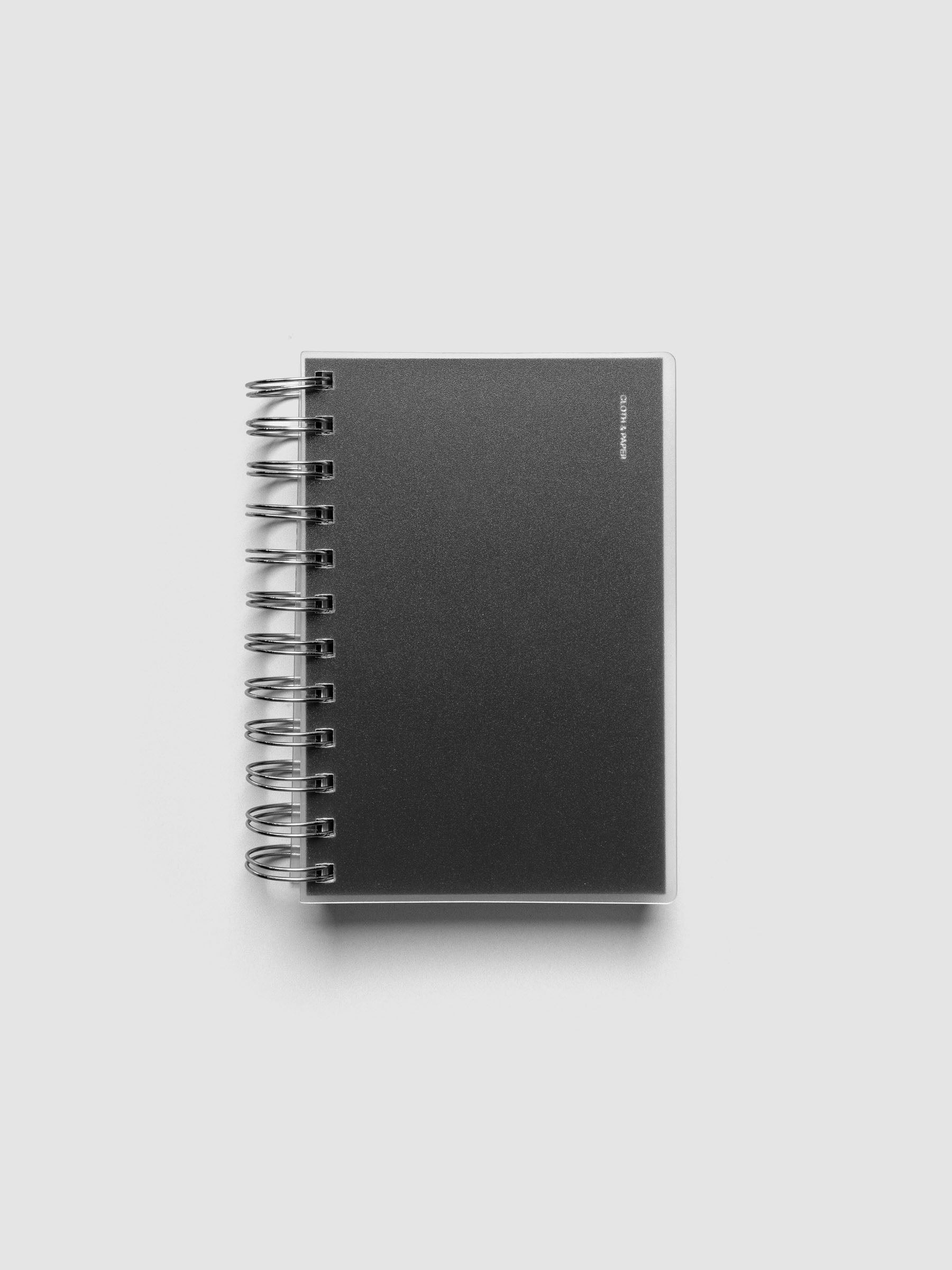 Spiral Notebook dashboard in the color Avant Garde shown in size CP Petite inside a notebook with the frosted transparent cover overlayed.
