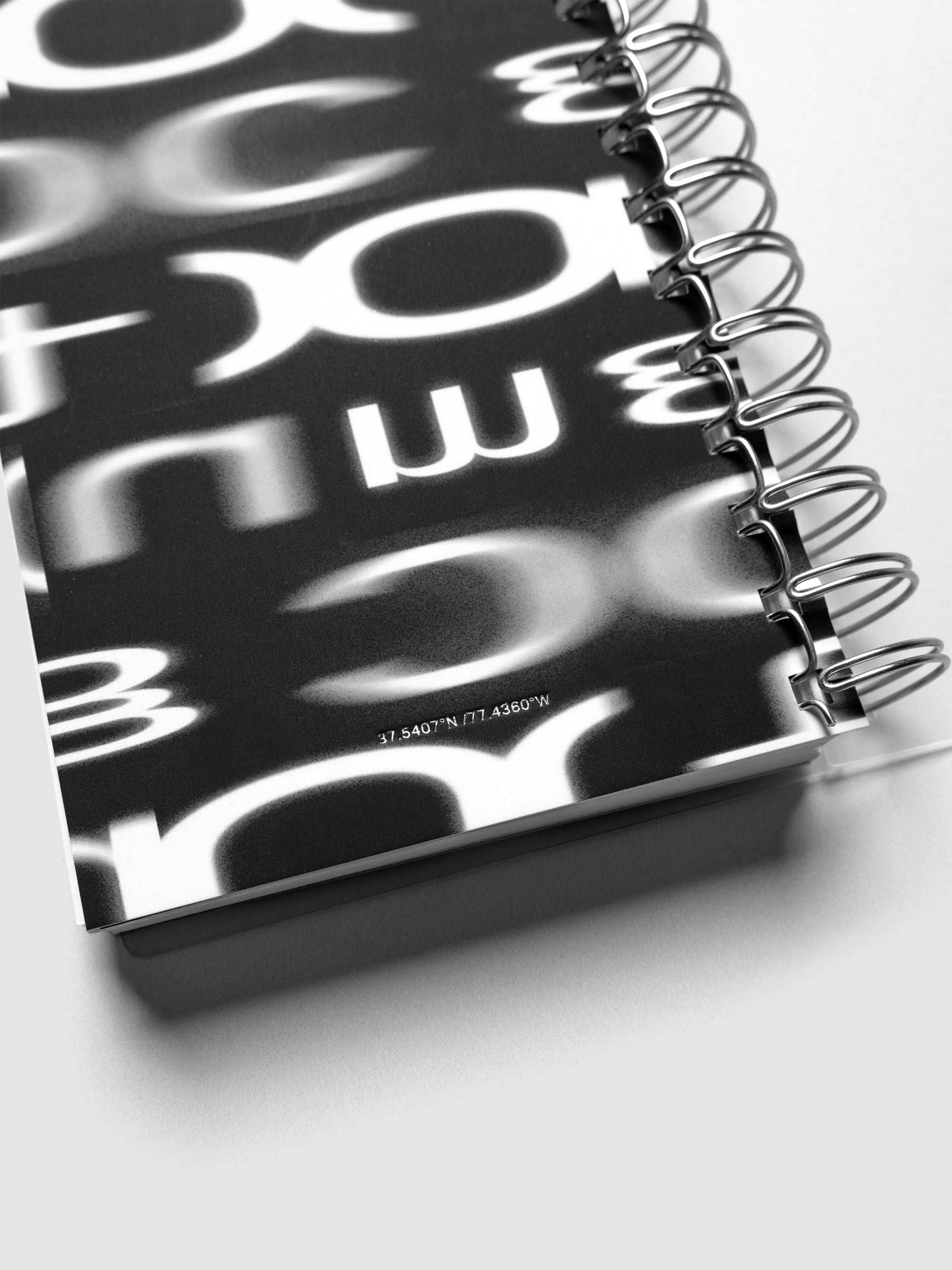 Detail view of the Spiral Notebook dashboard in the pattern Blurred Letters shown in size CP Petite against a neutral background.