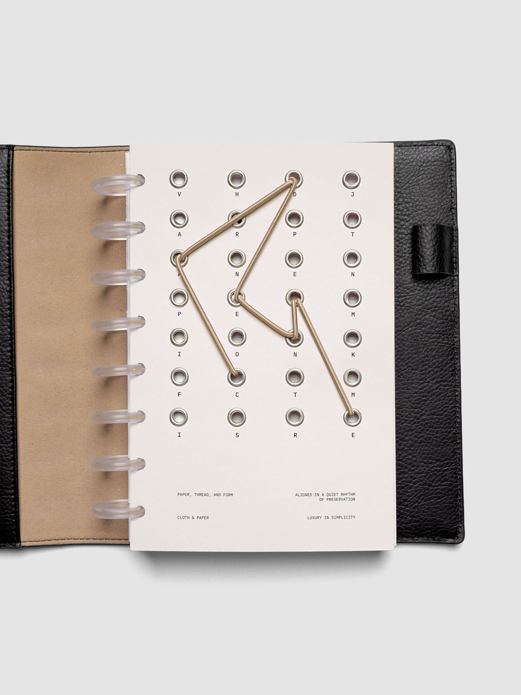 Cadence Dashboard with grommets and string on beige cardstock shown in size Half Letter for discbound planners and notebooks.