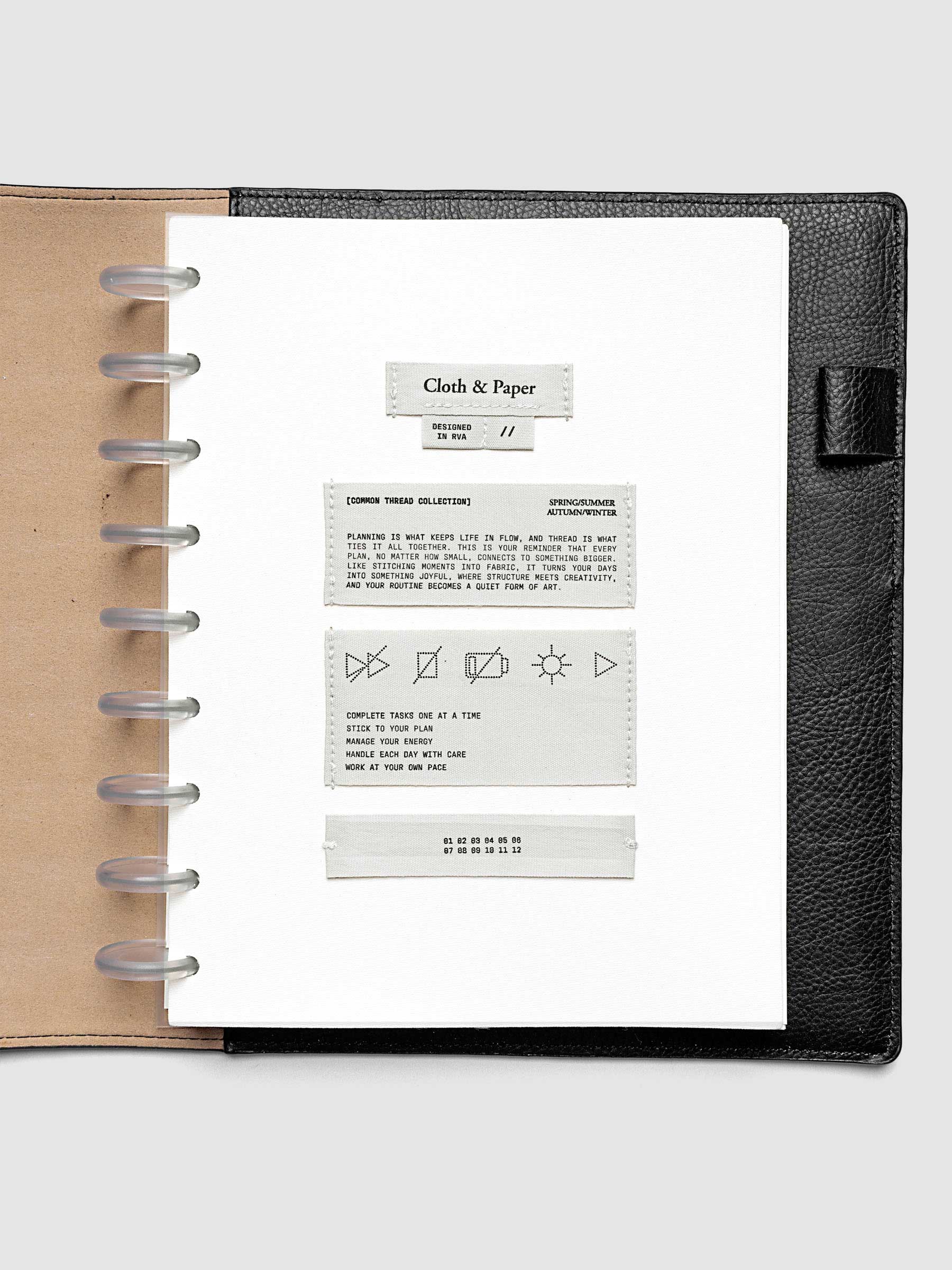Sewn Tags Planner Dashboard pre-punched for discbound planners in size HP Classic shown in a black leather folio.