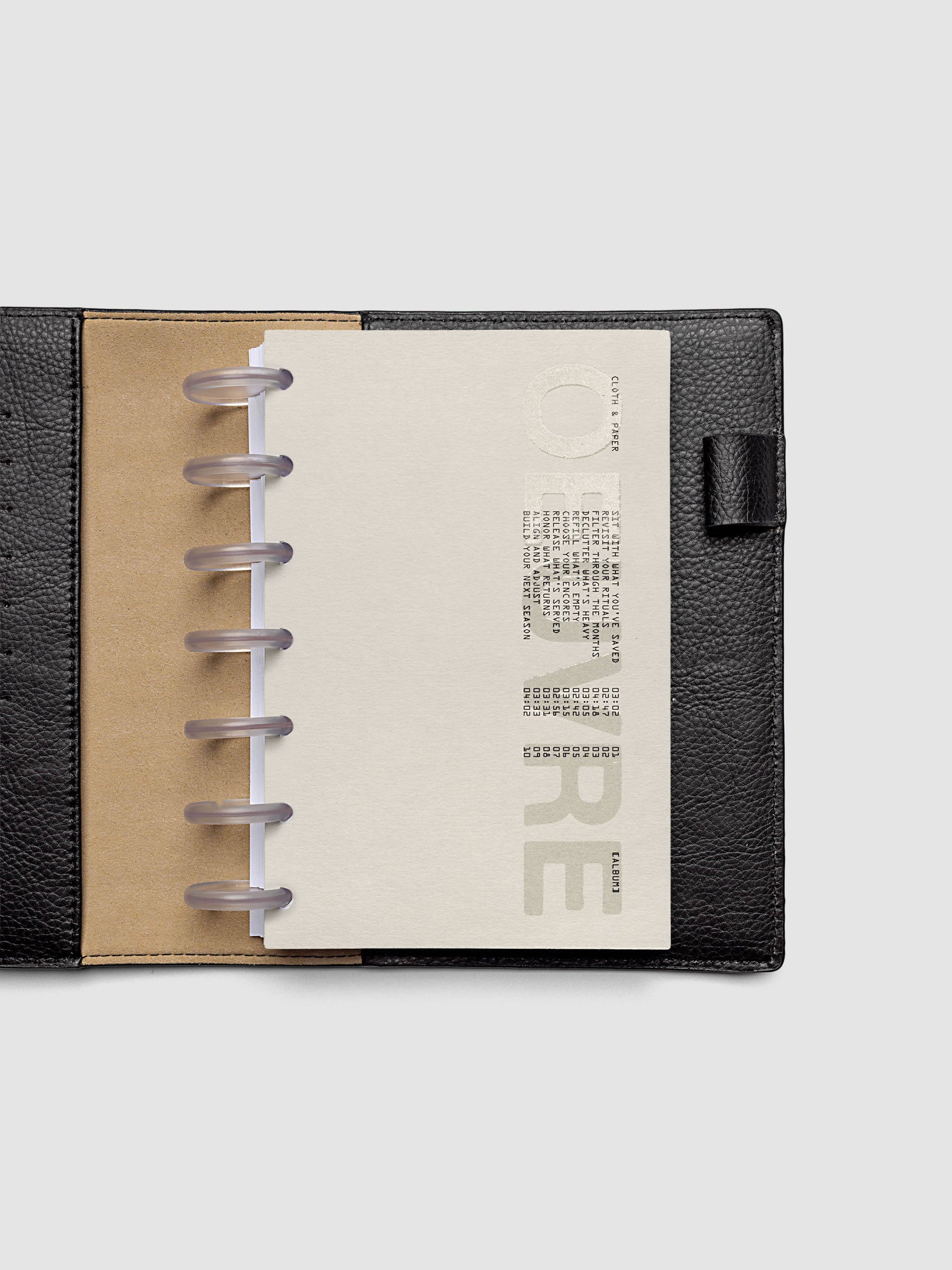 Oeuvre Planner Dashboard in HP Mini 7-Disc Punch size shown in a planner