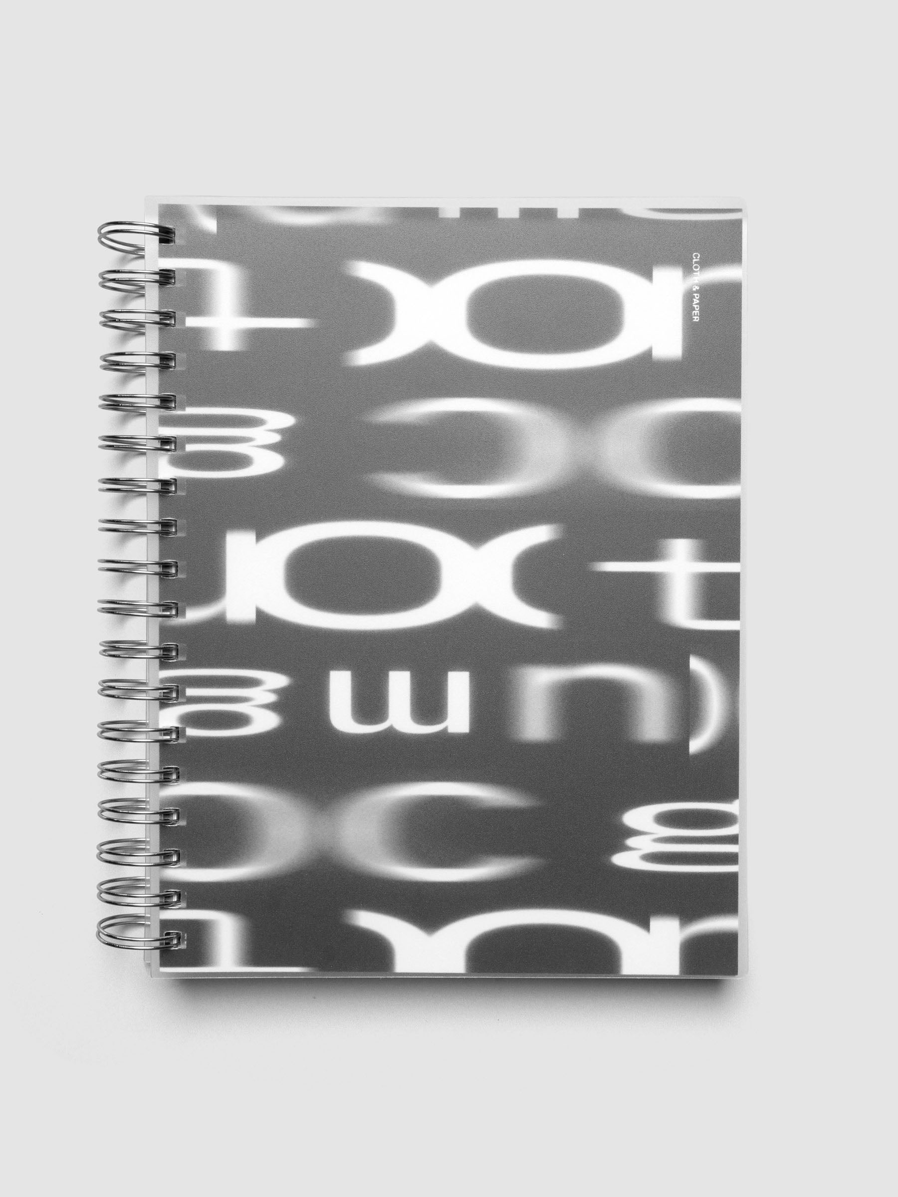 Spiral Notebook dashboard in the pattern Blurred Letters shown in size HP Classic inside a notebook with the frosted transparent cover overlayed.