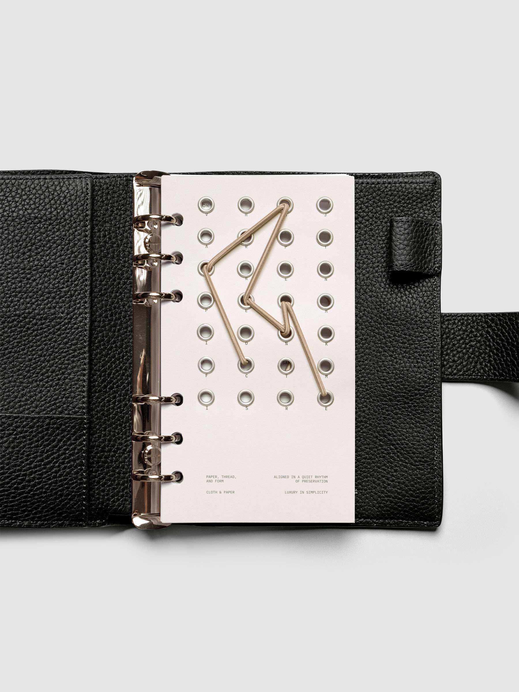 Cadence Dashboard with grommets and string on beige cardstock shown in size Personal for 6-ring planners and notebooks.