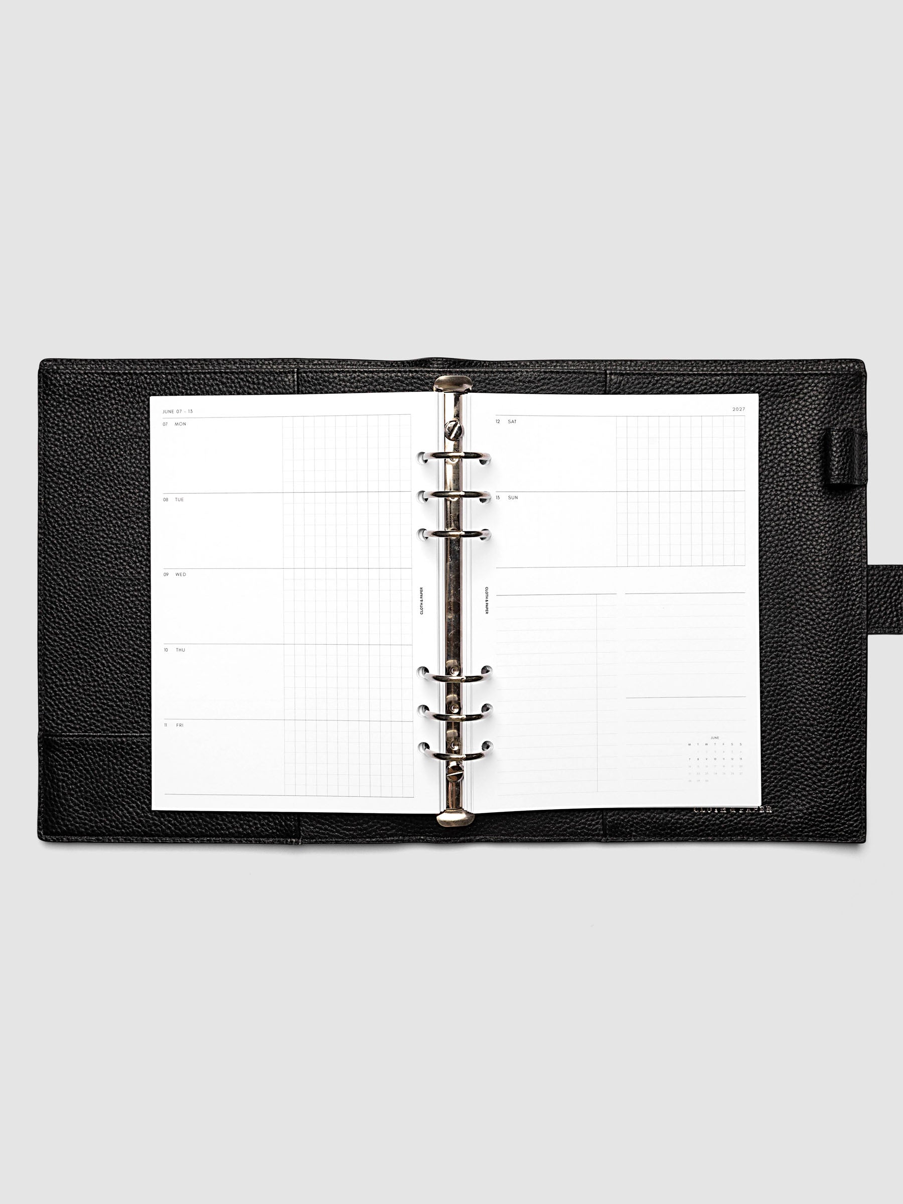 Open planner showing the full two-page 2027 Dated Weekly Horizontal Monday Start spread in A5 6-Ring Punch size, with split open and graph daily columns on the left and weekend dates, tasks, notes, and mini monthly calendar on the right