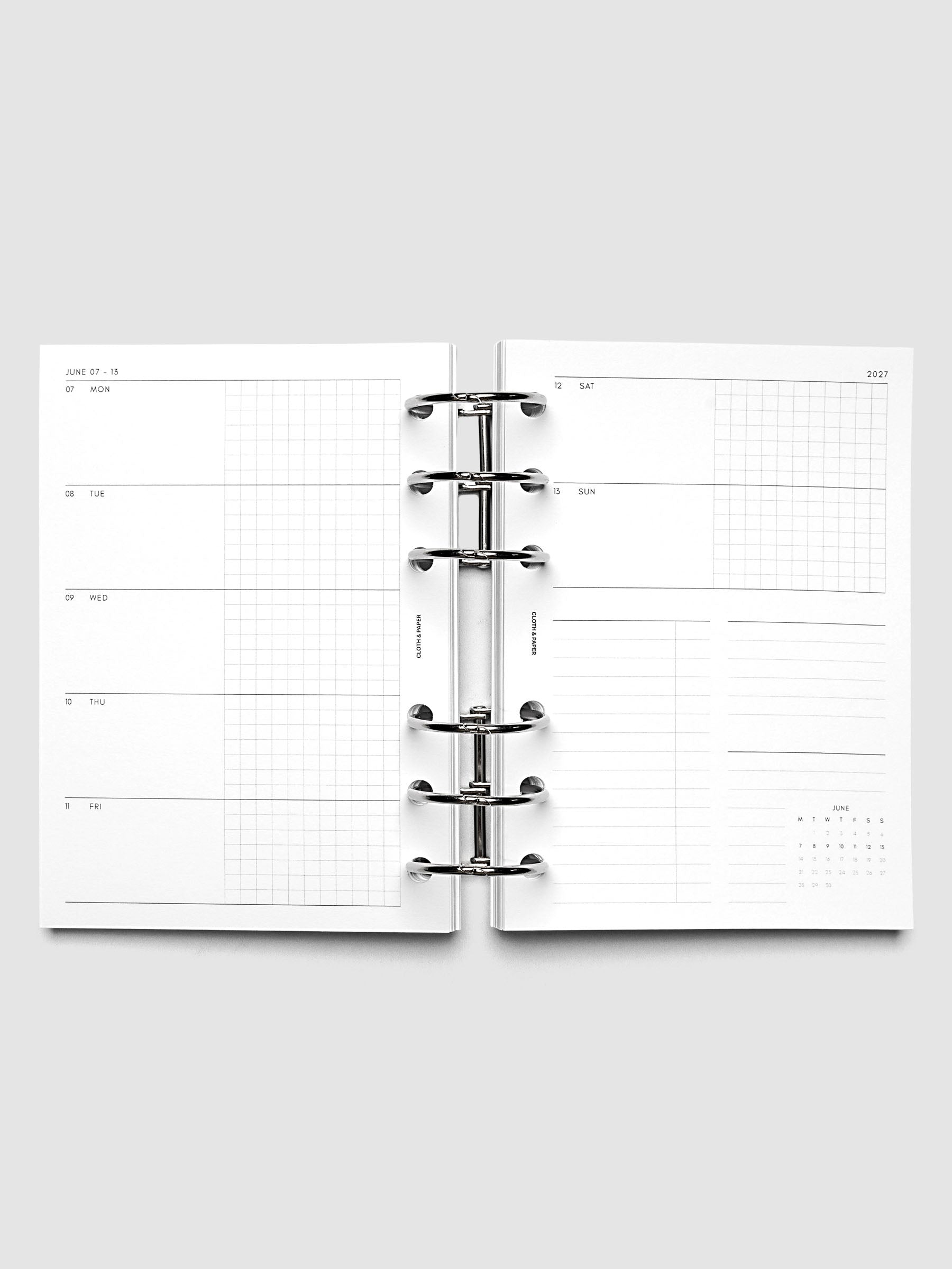 Open planner showing the full two-page 2027 Dated Weekly Horizontal Monday Start spread in A6 6-Ring Punch size, with split open and graph daily columns on the left and weekend dates, tasks, notes, and mini monthly calendar on the right