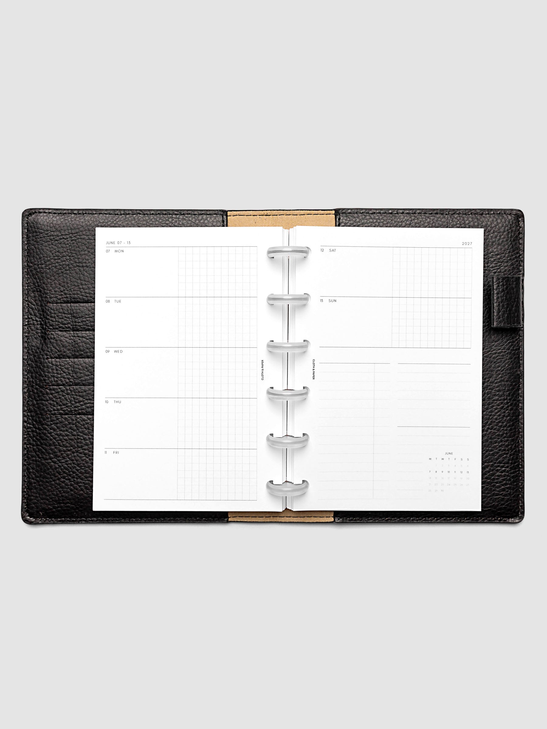 Open planner showing the full two-page 2027 Dated Weekly Horizontal Monday Start spread in CP Petite 6-Disc Punch size, with split open and graph daily columns on the left and weekend dates, tasks, notes, and mini monthly calendar on the right