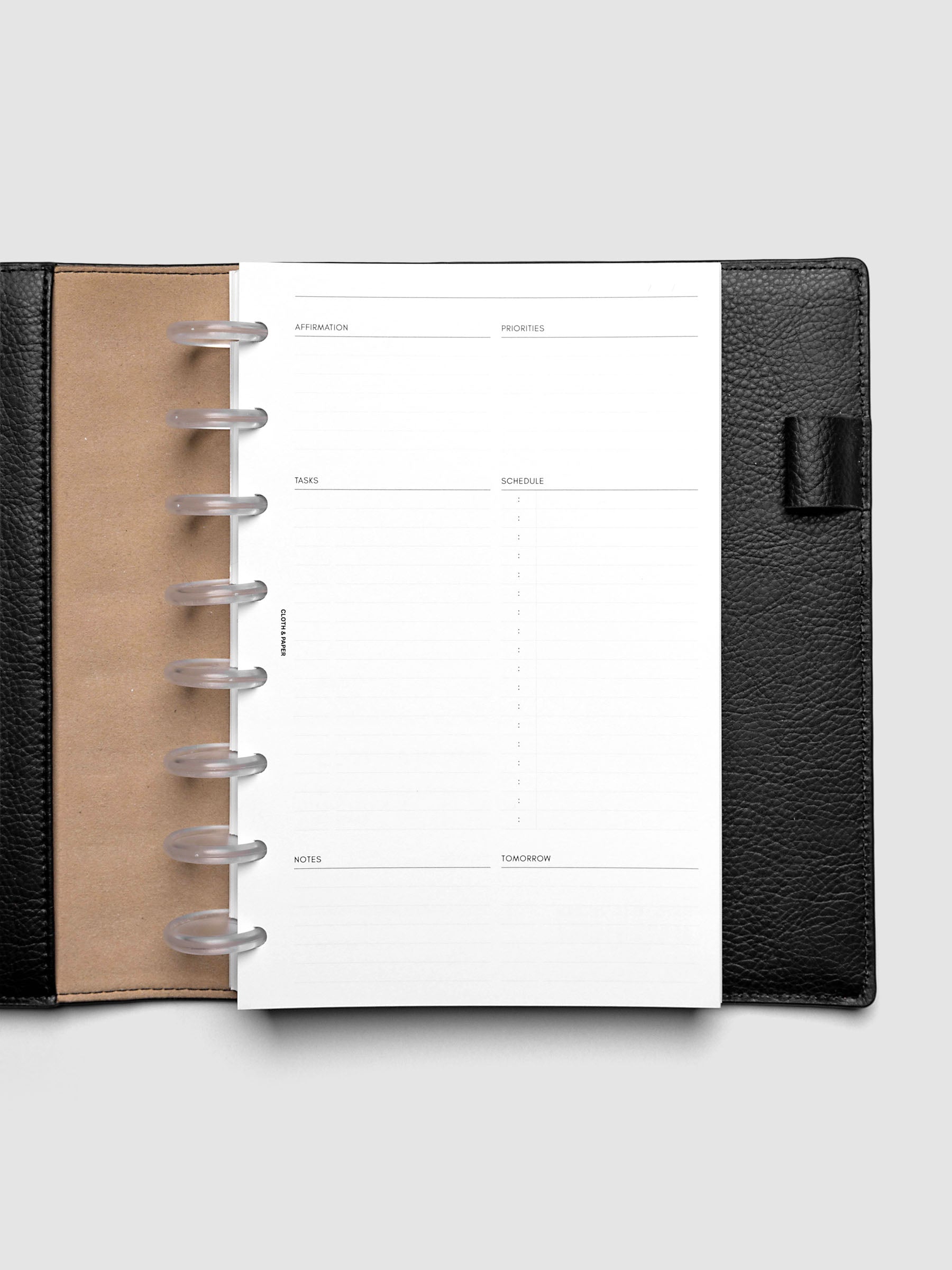 Daily Essentials Planner Inserts shown in size Half Letter inside a black folio.