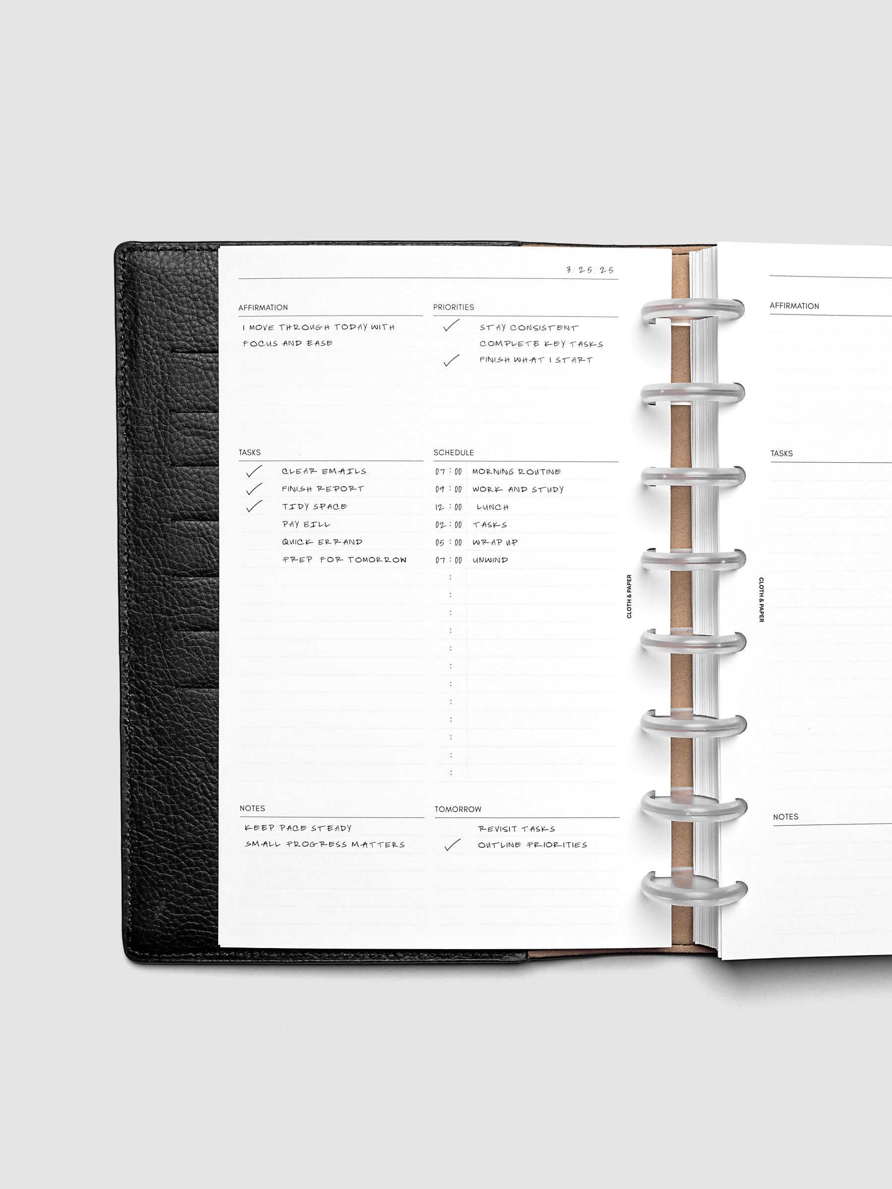 Demo page for the Daily Essentials Planner Inserts shown in size Half Letter inside a black folio.
