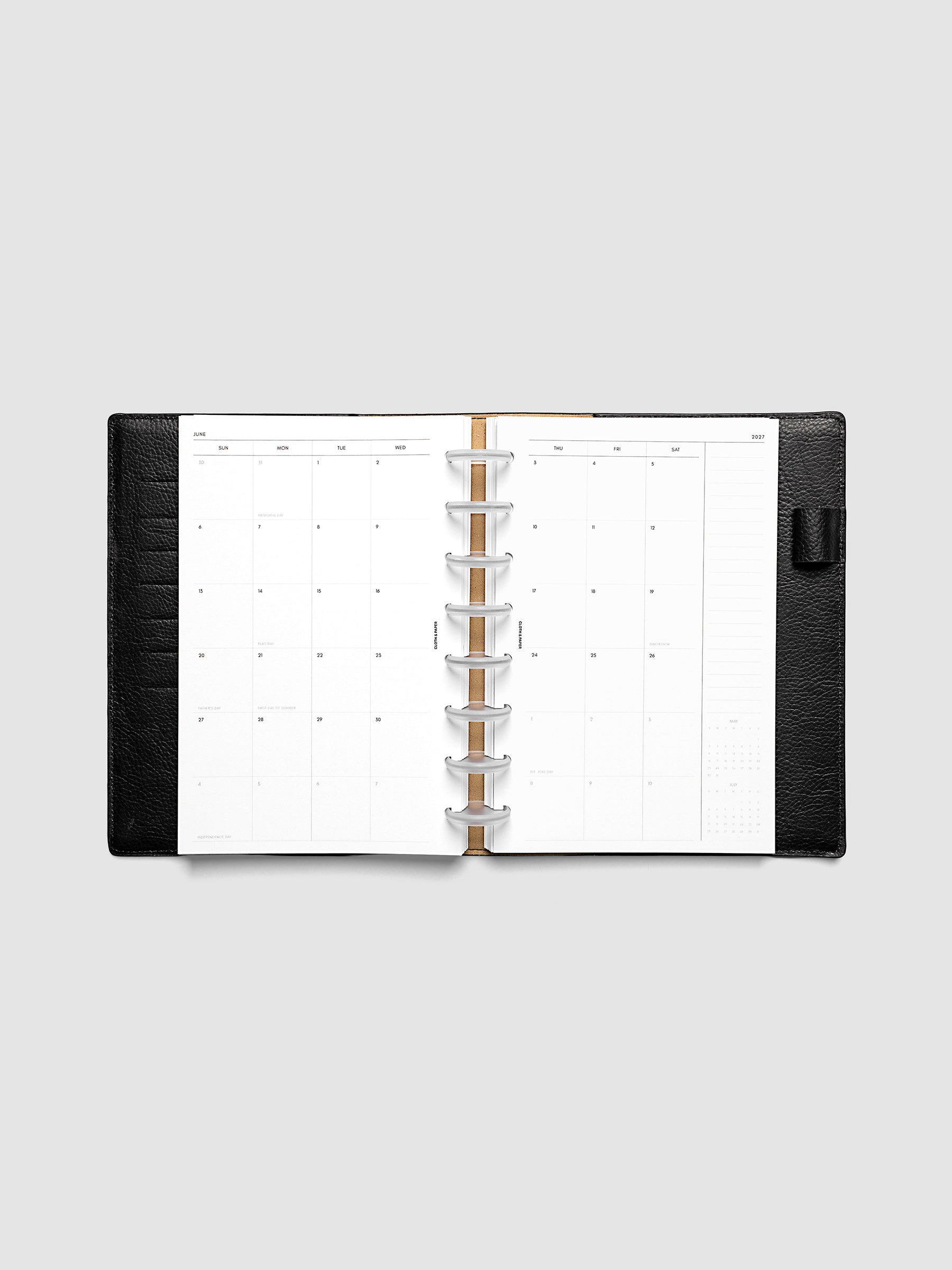 Open planner showing the full two-page 2027 Dated Monthly Sunday Start spread in Half Letter 8-Disc Punch size, with calendar grid, notes column, and mini calendars in the bottom right corner