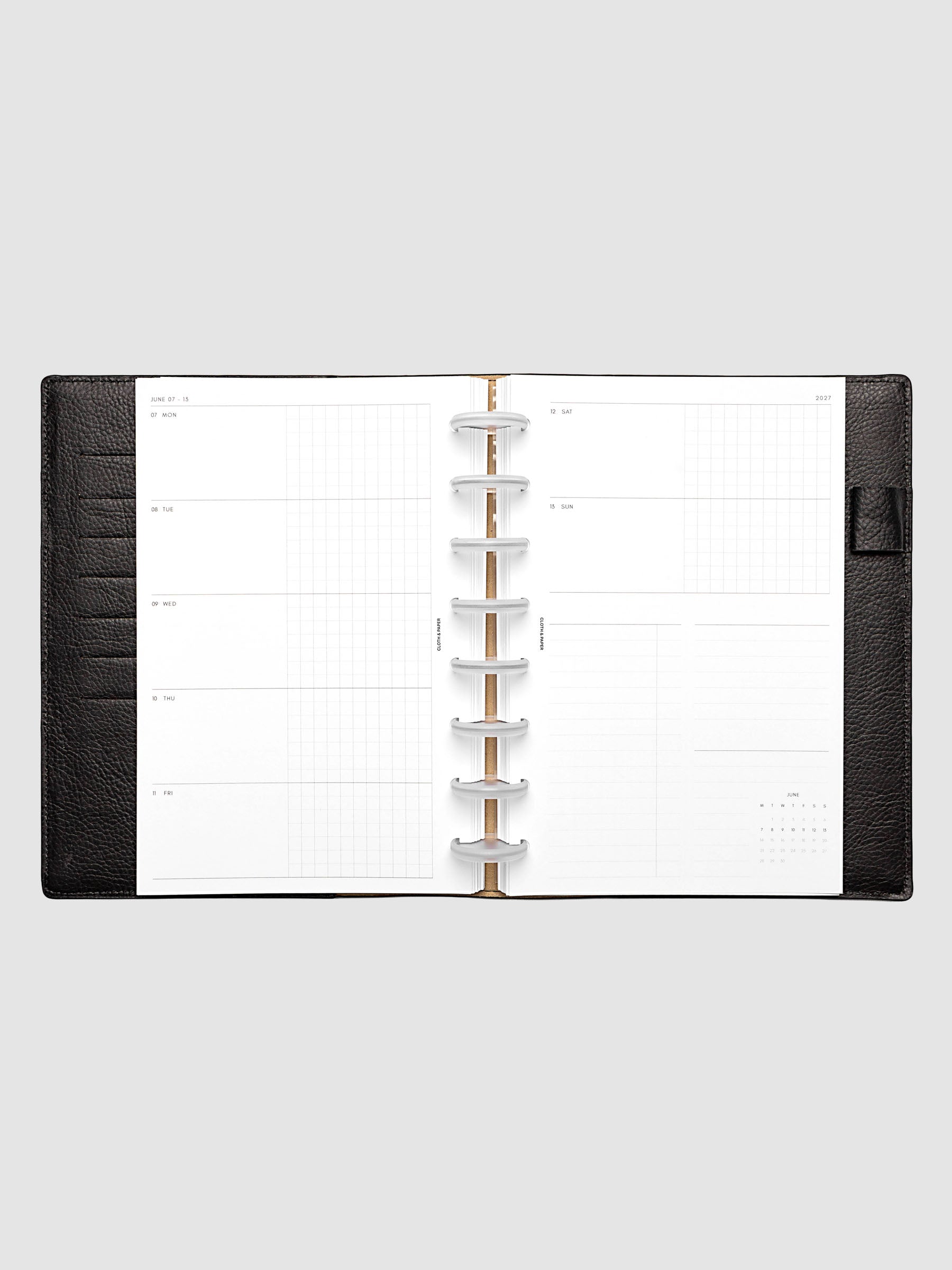 Open planner showing the full two-page 2027 Dated Weekly Horizontal Monday Start spread in Half Letter 8-Disc Punch size, with split open and graph daily columns on the left and weekend dates, tasks, notes, and mini monthly calendar on the right