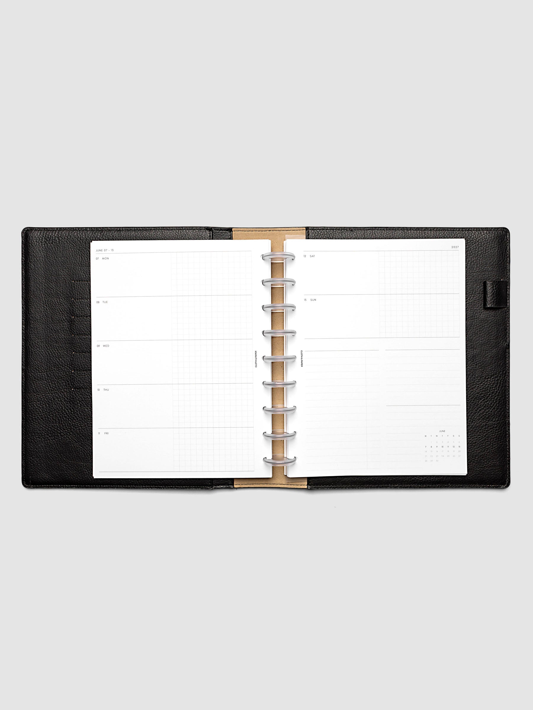 Open planner showing the full two-page 2027 Dated Weekly Horizontal Monday Start spread in HP Classic 9-Disc Punch size, with split open and graph daily columns on the left and weekend dates, tasks, notes, and mini monthly calendar on the right
