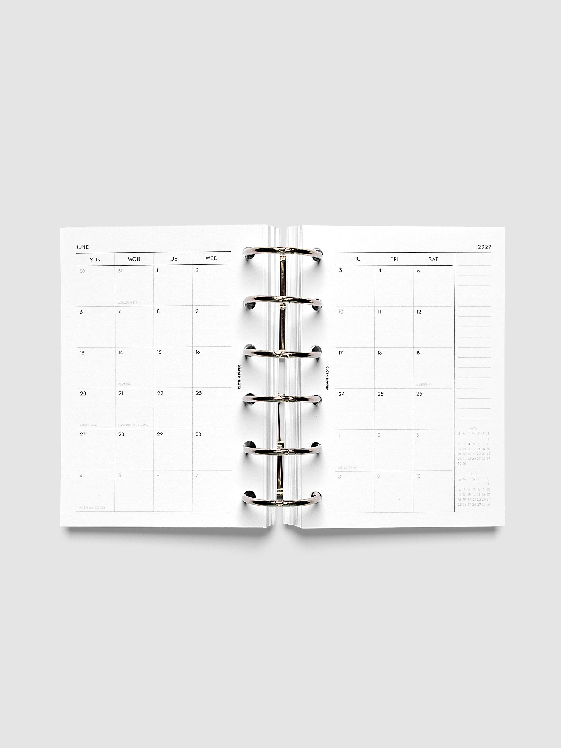 Open planner showing the full two-page 2027 Dated Monthly Sunday Start spread in Pocket 6-Ring Punch size, with calendar grid, notes column, and mini calendars in the bottom right corner