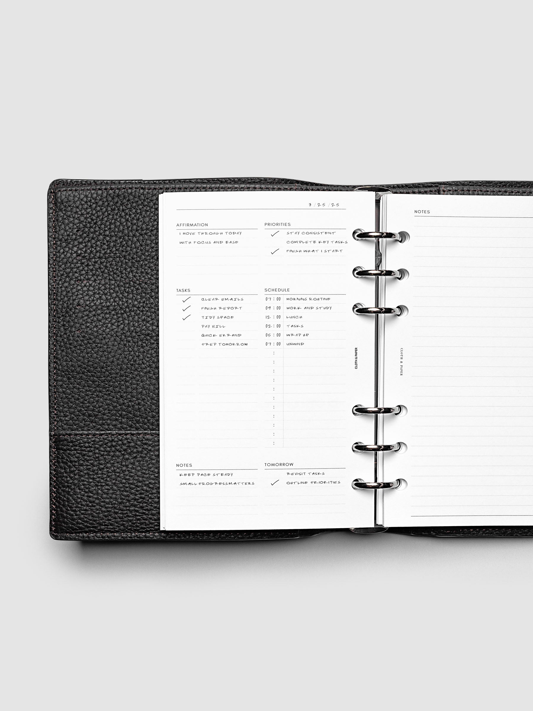 Demo page for the Daily Essentials Planner Inserts shown in size Personal inside a black agenda.