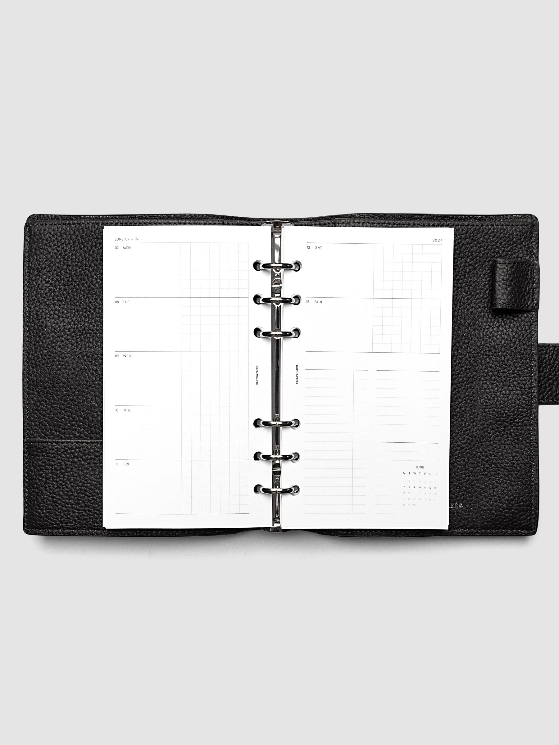 Open planner showing the full two-page 2027 Dated Weekly Horizontal Monday Start spread in Personal 6-Ring Punch size, with split open and graph daily columns on the left and weekend dates, tasks, notes, and mini monthly calendar on the right