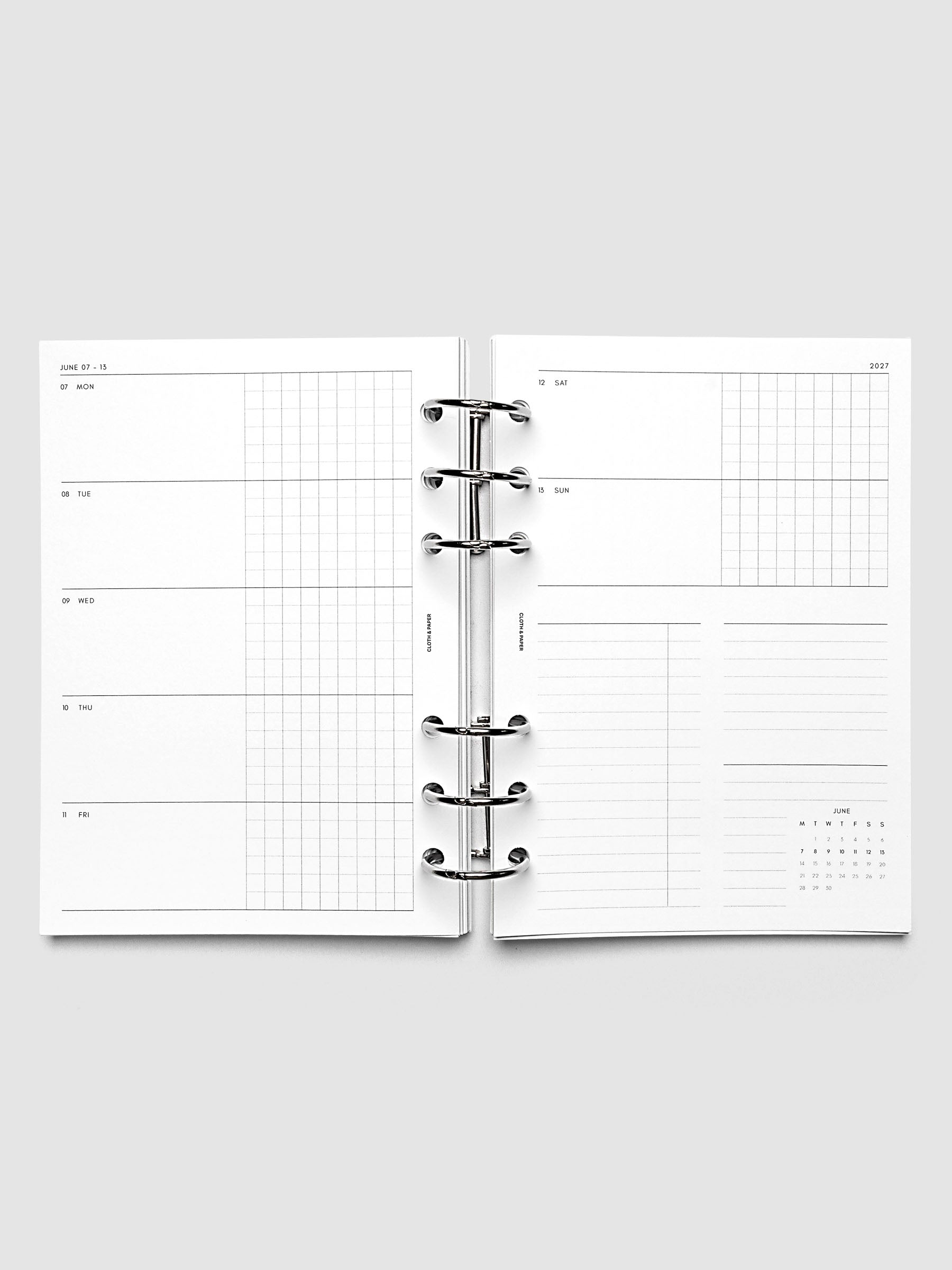 Open planner showing the full two-page 2027 Dated Weekly Horizontal Monday Start spread in Personal Wide 6-Ring Punch size, with split open and graph daily columns on the left and weekend dates, tasks, notes, and mini monthly calendar on the right