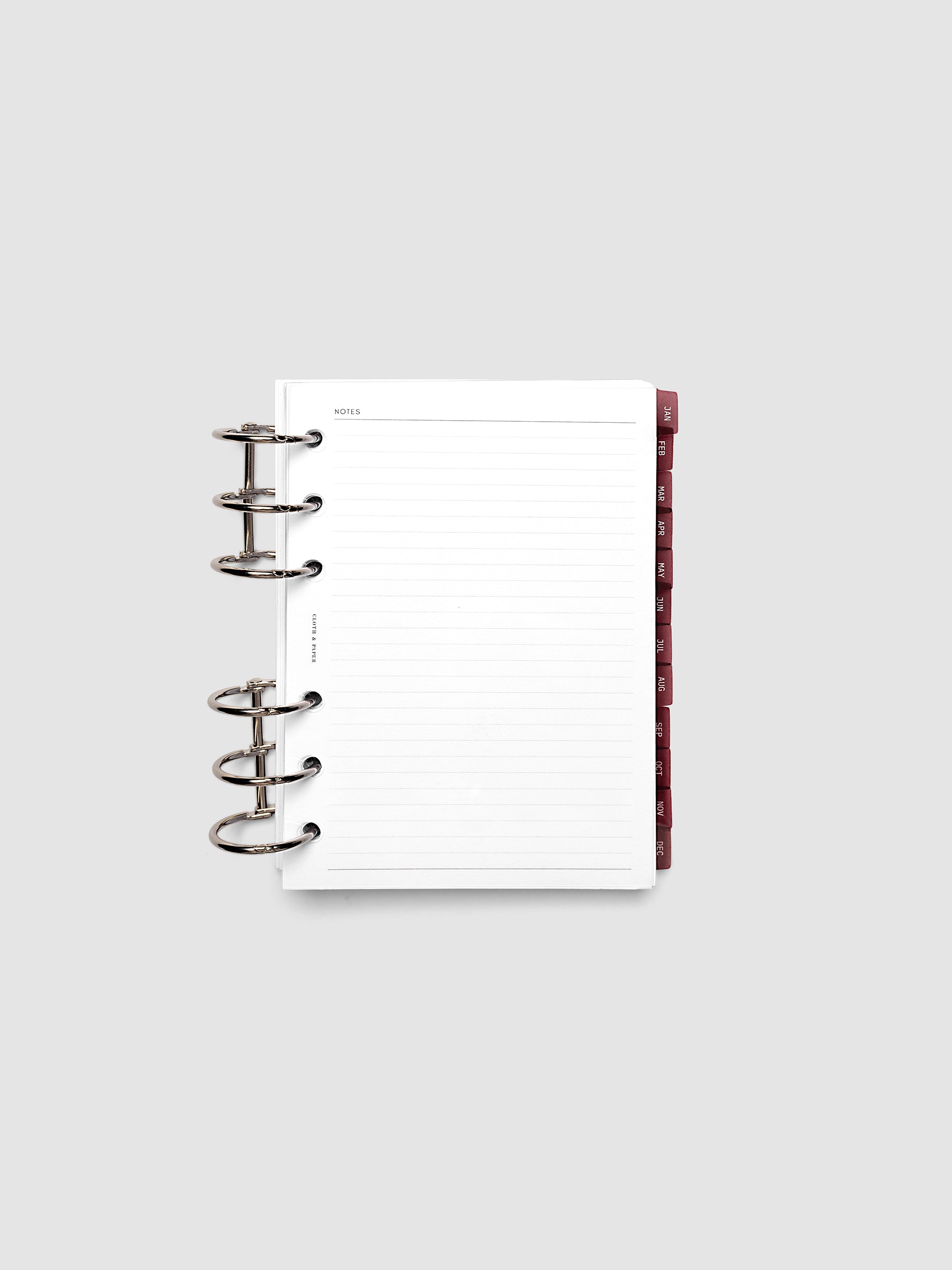 A6 6-Ring Punch Ultra-Thin Monthly Dividers in deep red shown tabbed inside a planner