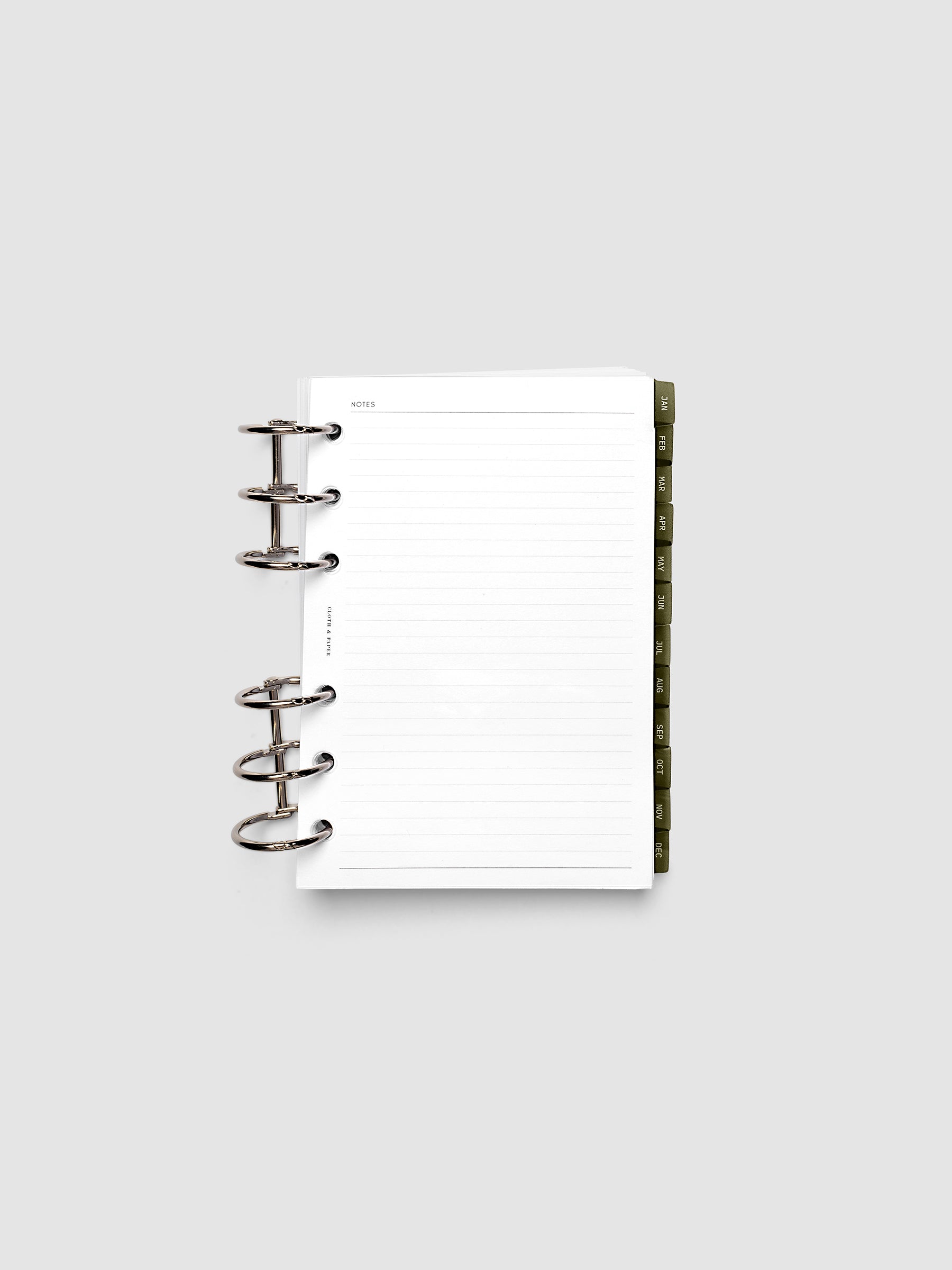 A6 6-Ring Punch Ultra-Thin Monthly Dividers in olive green shown tabbed inside a planner